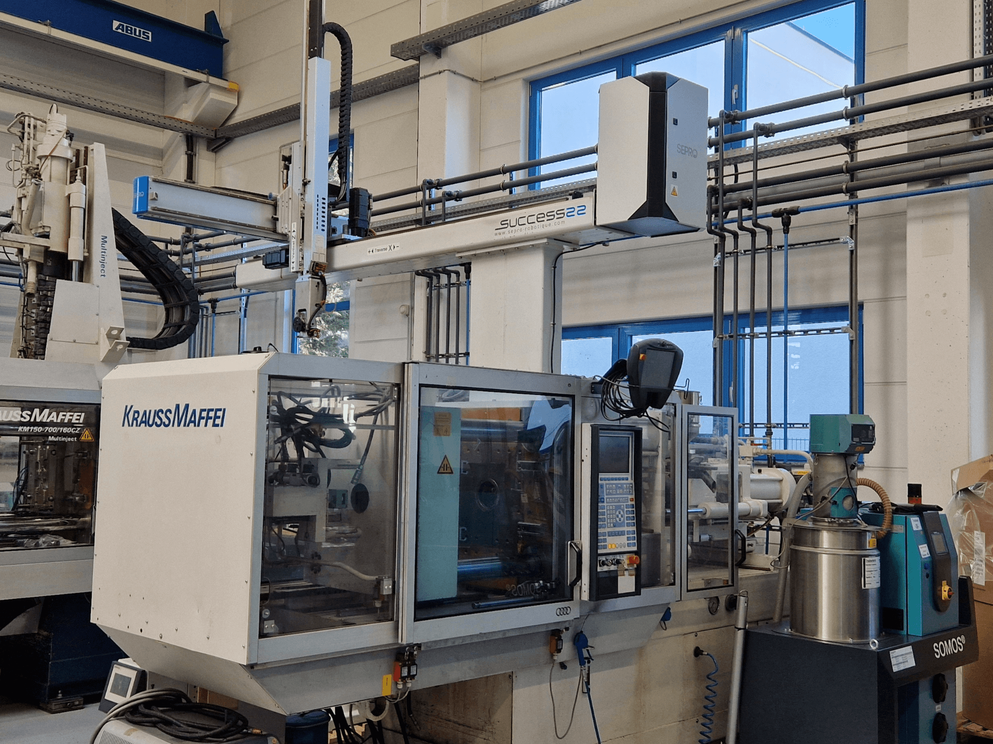 Machine de moulage par injection KraussMaffei Success 22 avec panneau de commande, vue de face en usine.