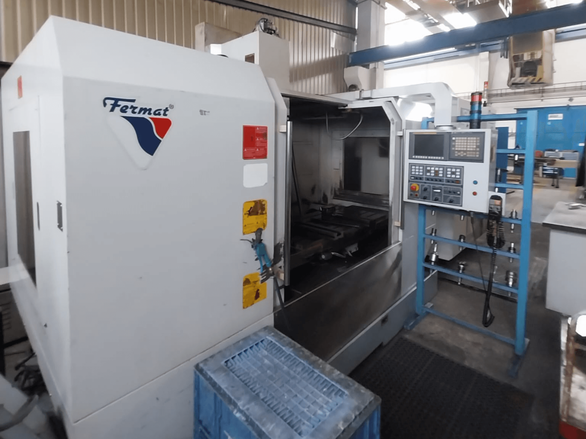 Centre d'usinage vertical FERMAT VMF 1000, vue de face, présentant le panneau de commande et l'intérieur de la machine.
