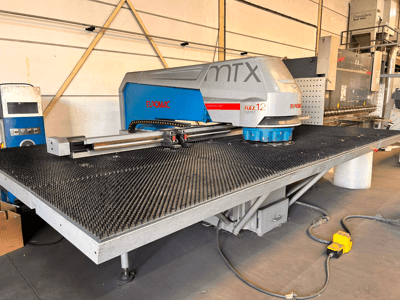 Poinçonneuse à commande numérique Euromac MTX FLEX 12, vue de face, équipée d'une grande table perforée et d'un panneau de commande.
