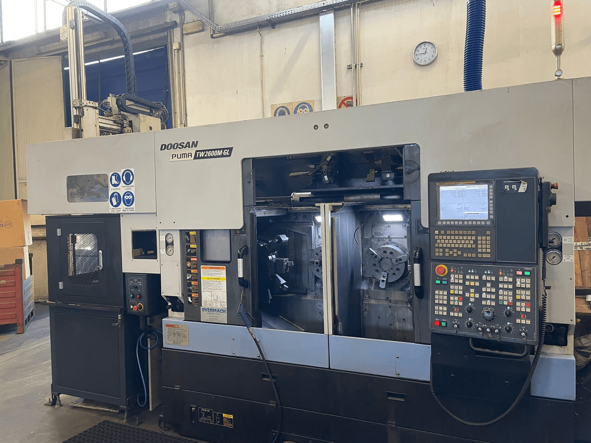 Tour CNC Doosan Puma TW2600M GL, vue de face, montrant le panneau de commande numérique et l'intérieur de la machine avec les porte-outils.