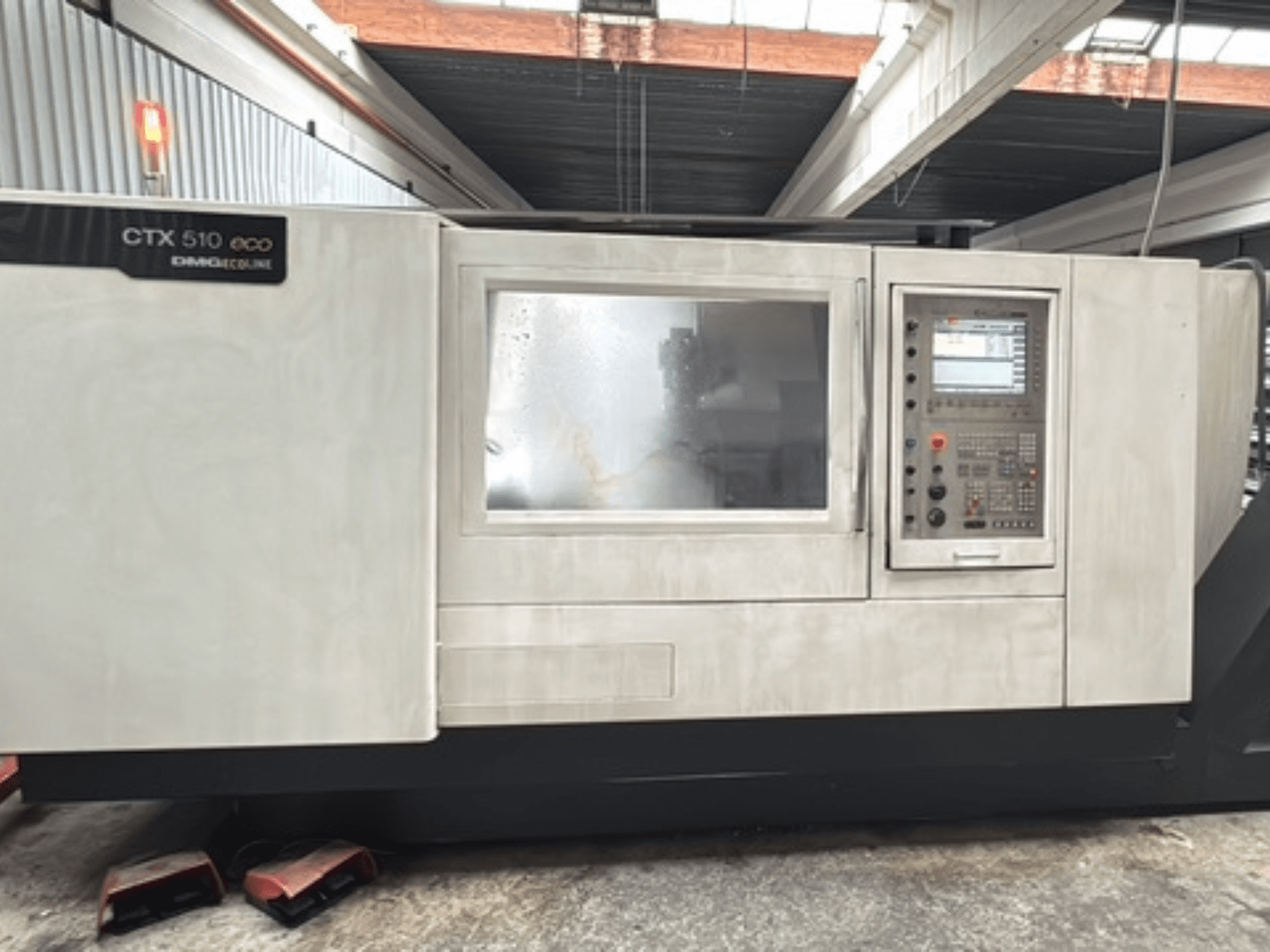 Tour horizontal DMG CTX 510 ecoline, vue de face, montrant le panneau de commande et la fenêtre sur le corps de la machine.