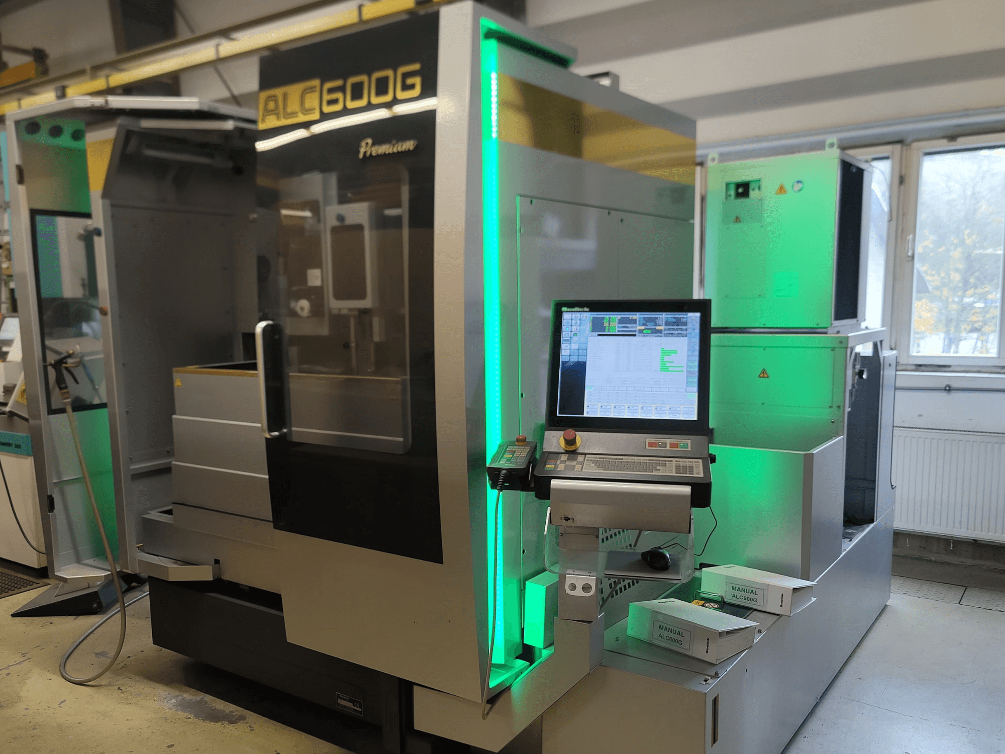 Machine d'électroérosion à fil Sodick ALC600G Premium, vue de face, montrant le panneau de commande et les détails extérieurs éclairés.