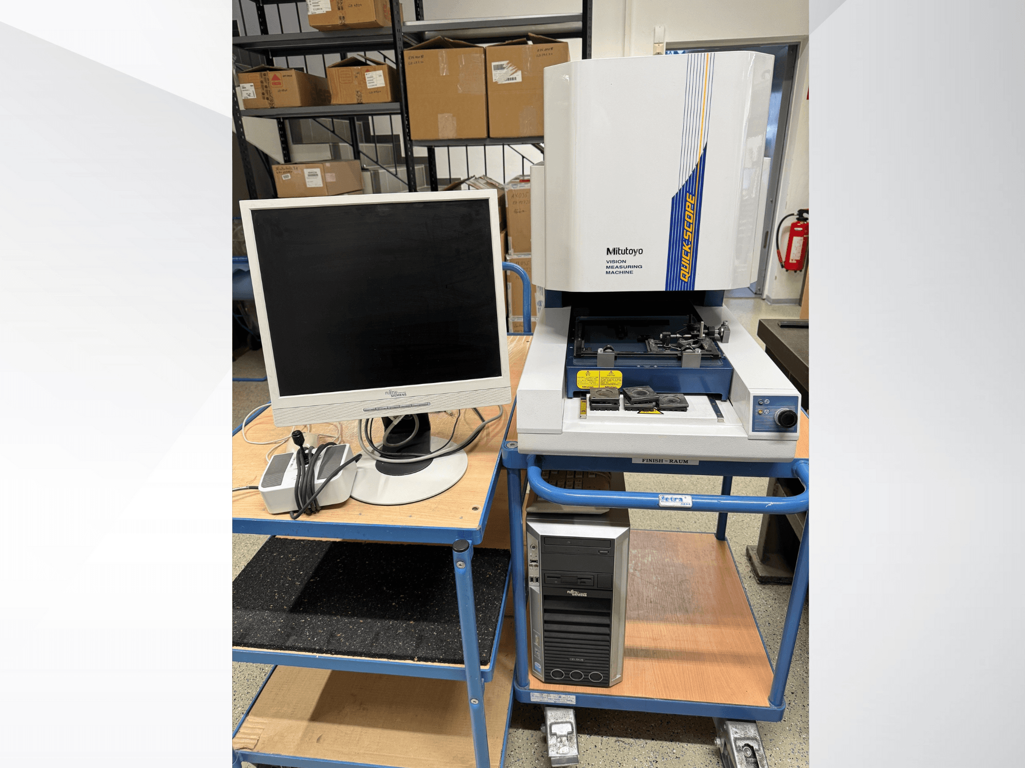 Machine de mesure par vision Mitutoyo Quick Scope avec moniteur, PC et accessoires, vue de face, sur un chariot bleu.