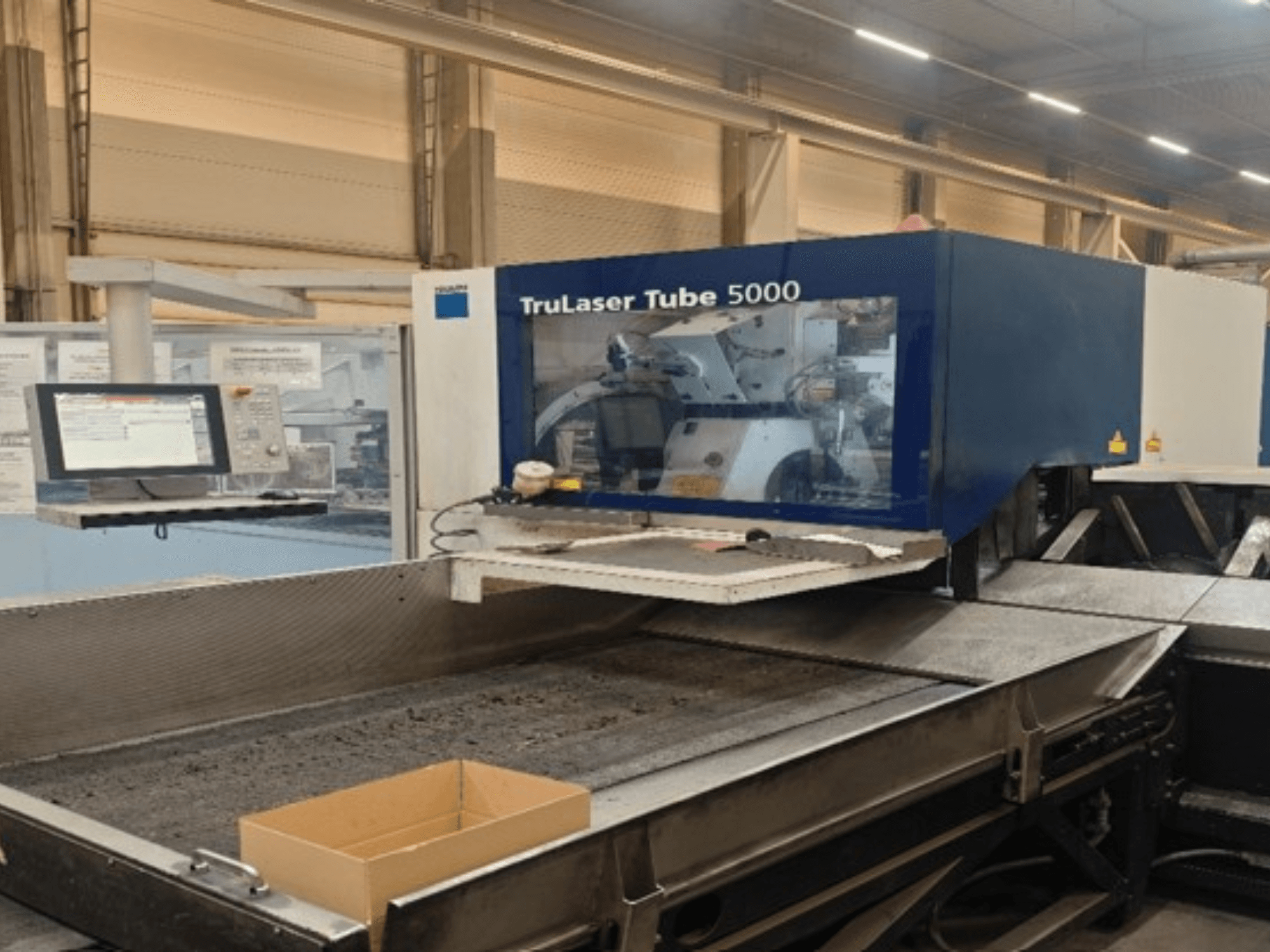 Vue de face de la TRUMPF TruLaser Tube 5000, mettant en évidence le panneau de commande et la zone de découpe pour des opérations de découpe de tubes de haute précision.