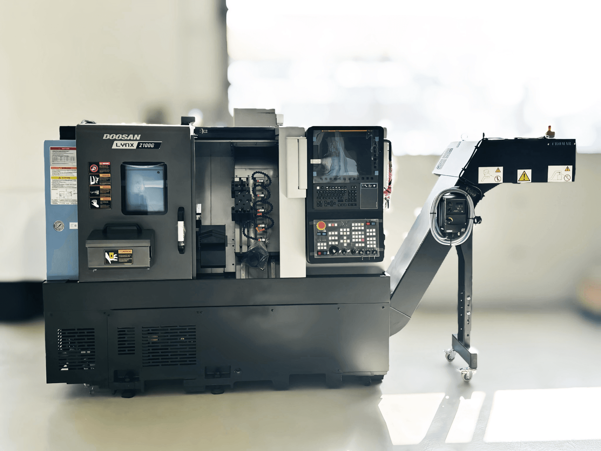 Tour suisse DOOSAN LYNX 2100GA en vue latérale avec le panneau de commande et le porte-outil visibles.