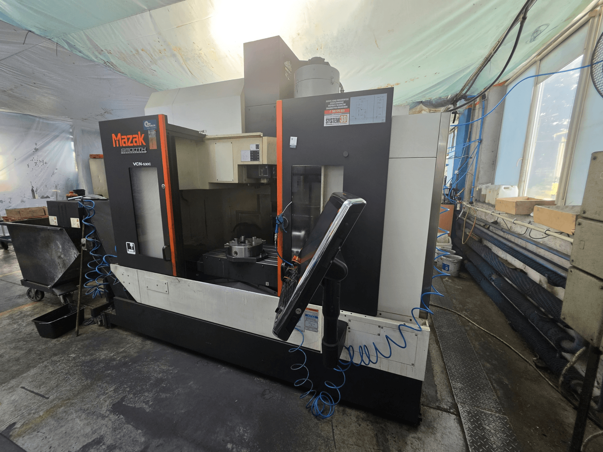 Vue de face du centre d'usinage vertical Mazak VCN-530C, mettant en évidence le panneau de commande, la zone d'usinage et le porte-outils.