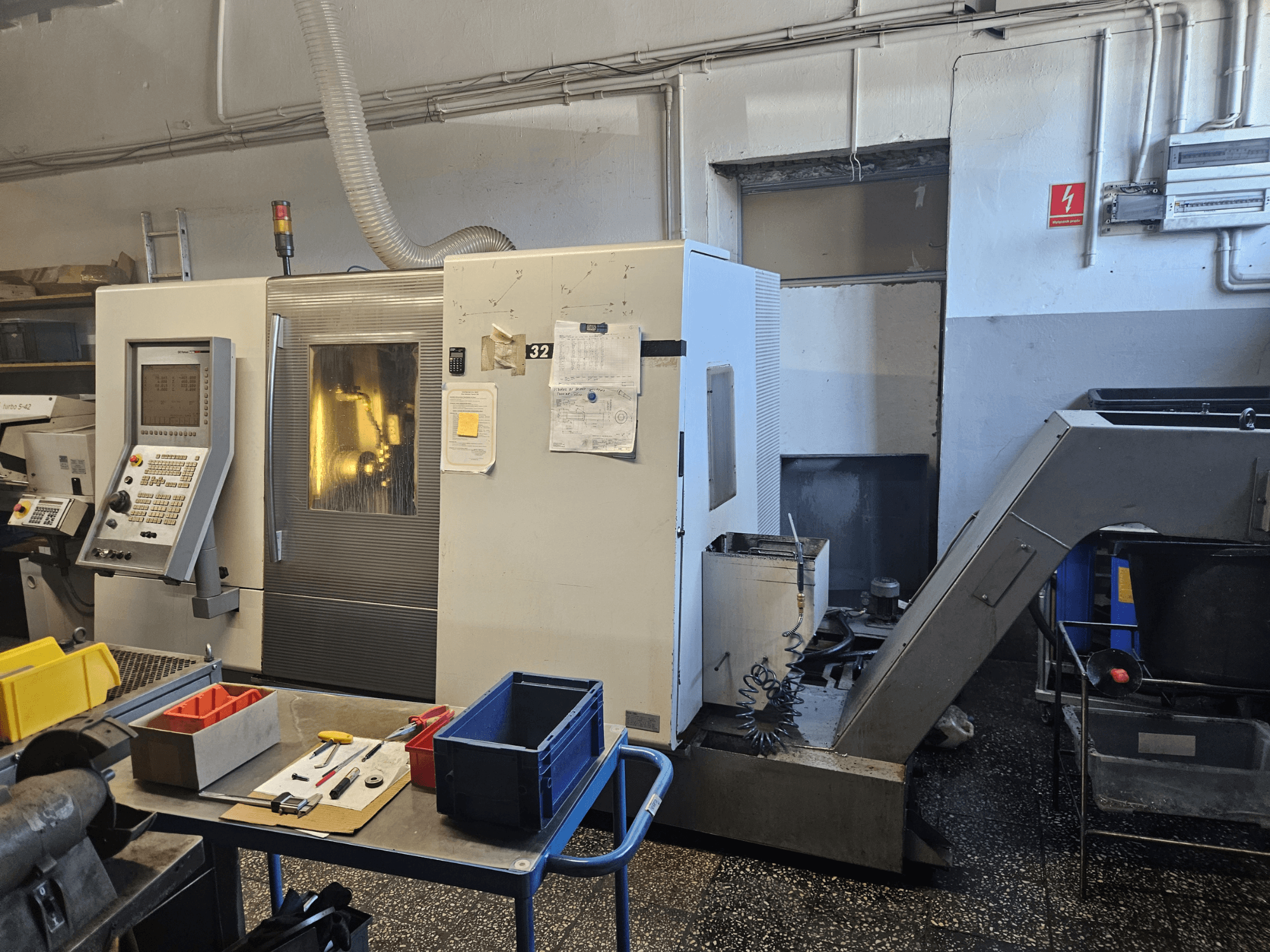 Tour multibroche DMG GILDEMEISTER Sprint 32 linear, vue de face dans un atelier, avec panneau de commande et outils visibles.