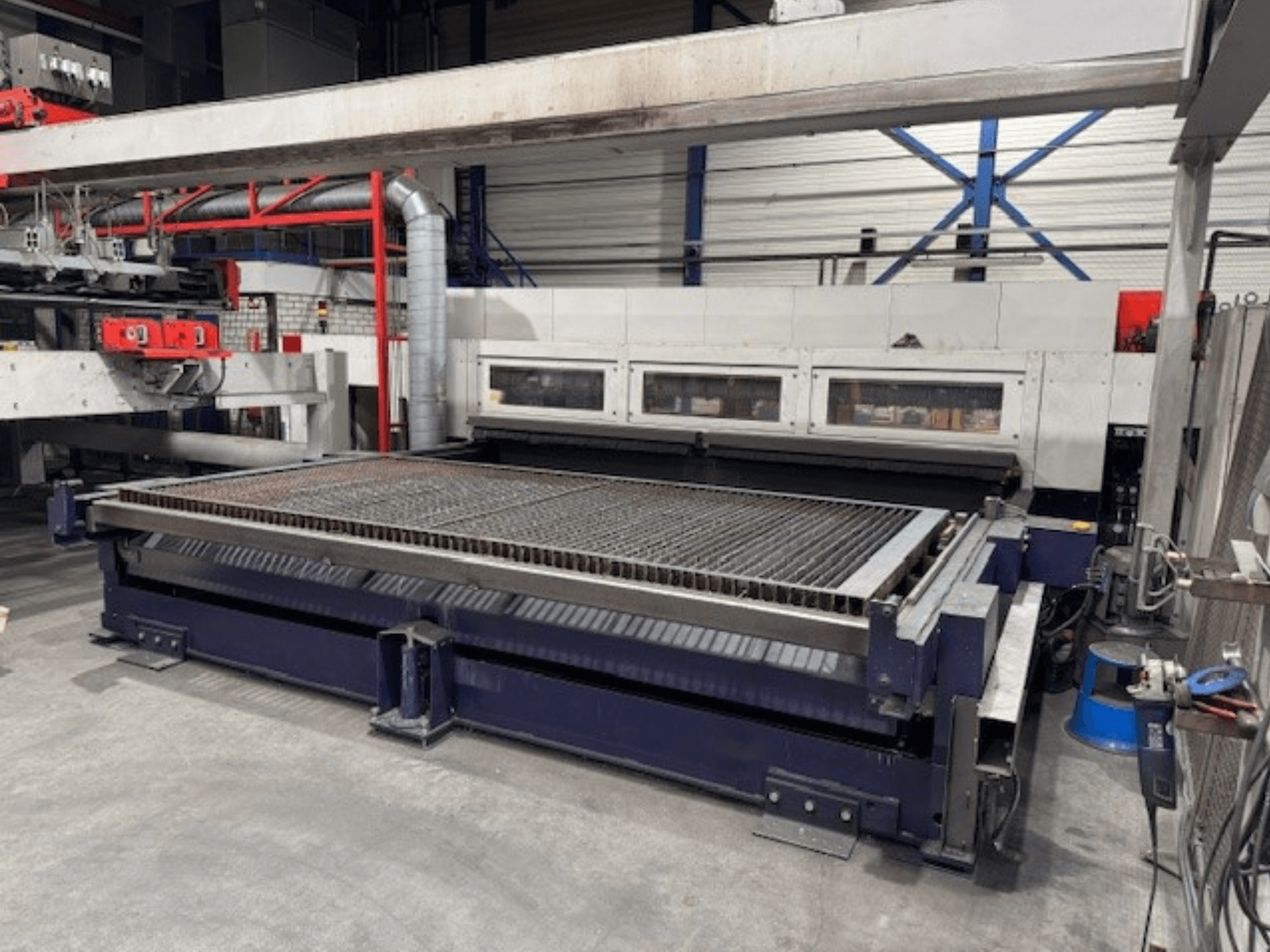Machine de découpe laser CO2 BySpeed 4020 de Bystronic vue de face, avec une table de découpe spacieuse et des composants mécaniques.