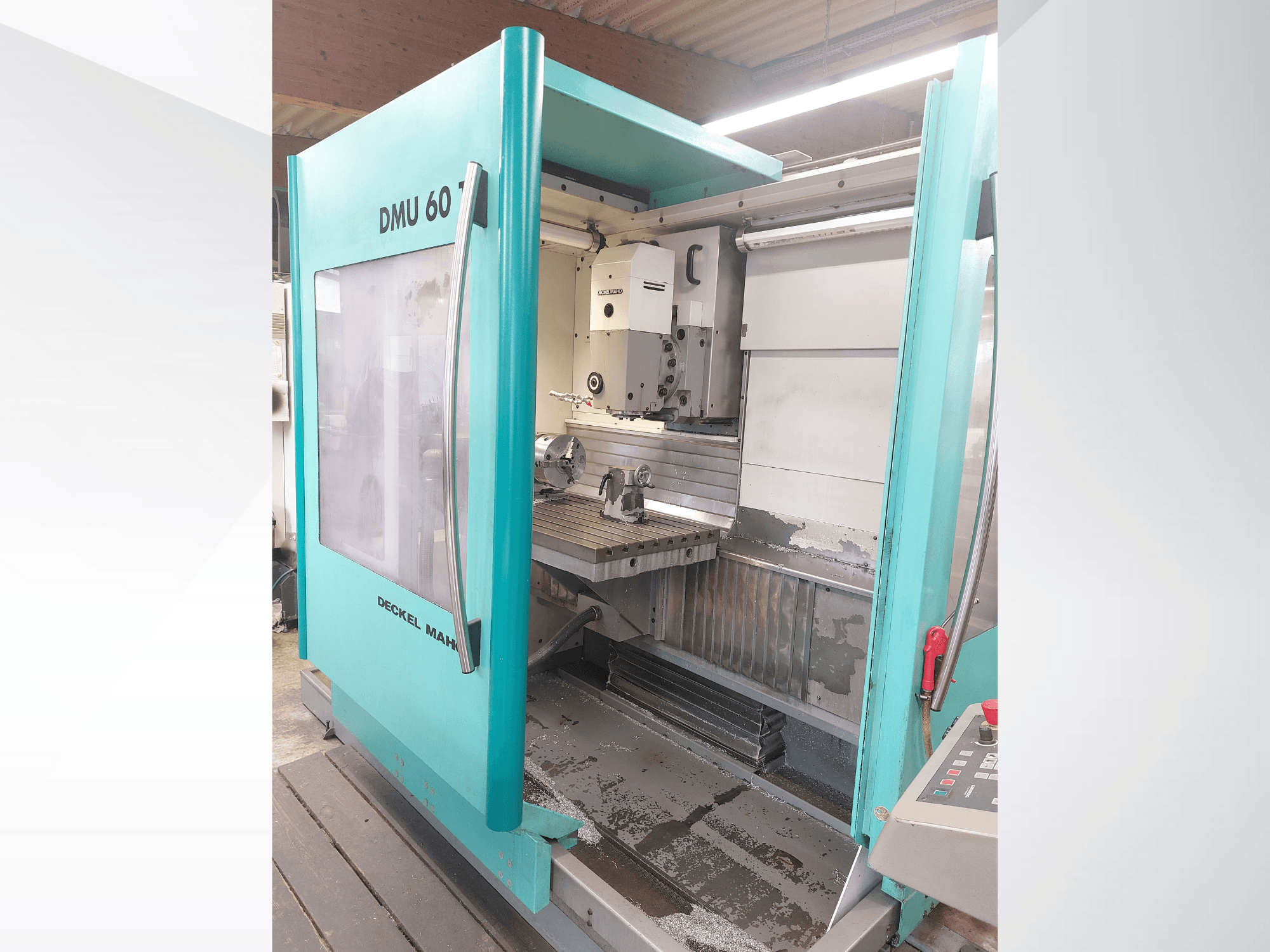 Machine CNC Deckel MAHO DMU 60, vue de face. Panneau de commande visible et table de fraisage avec réglage de la pièce à usiner.