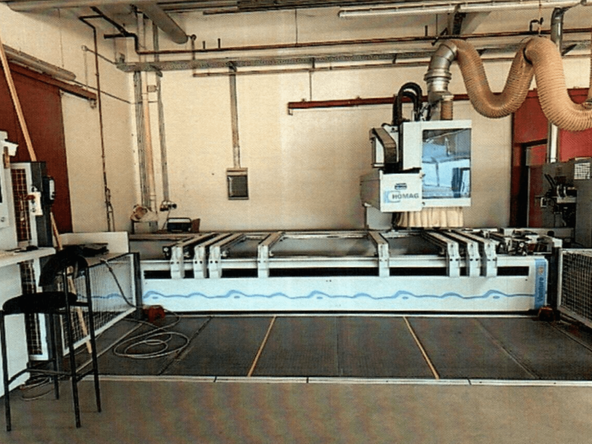 Centre d'usinage du bois HOMAG BAZ 211/40K CNC dans un atelier, présentant le panneau de commande de la machine et la zone de coupe.