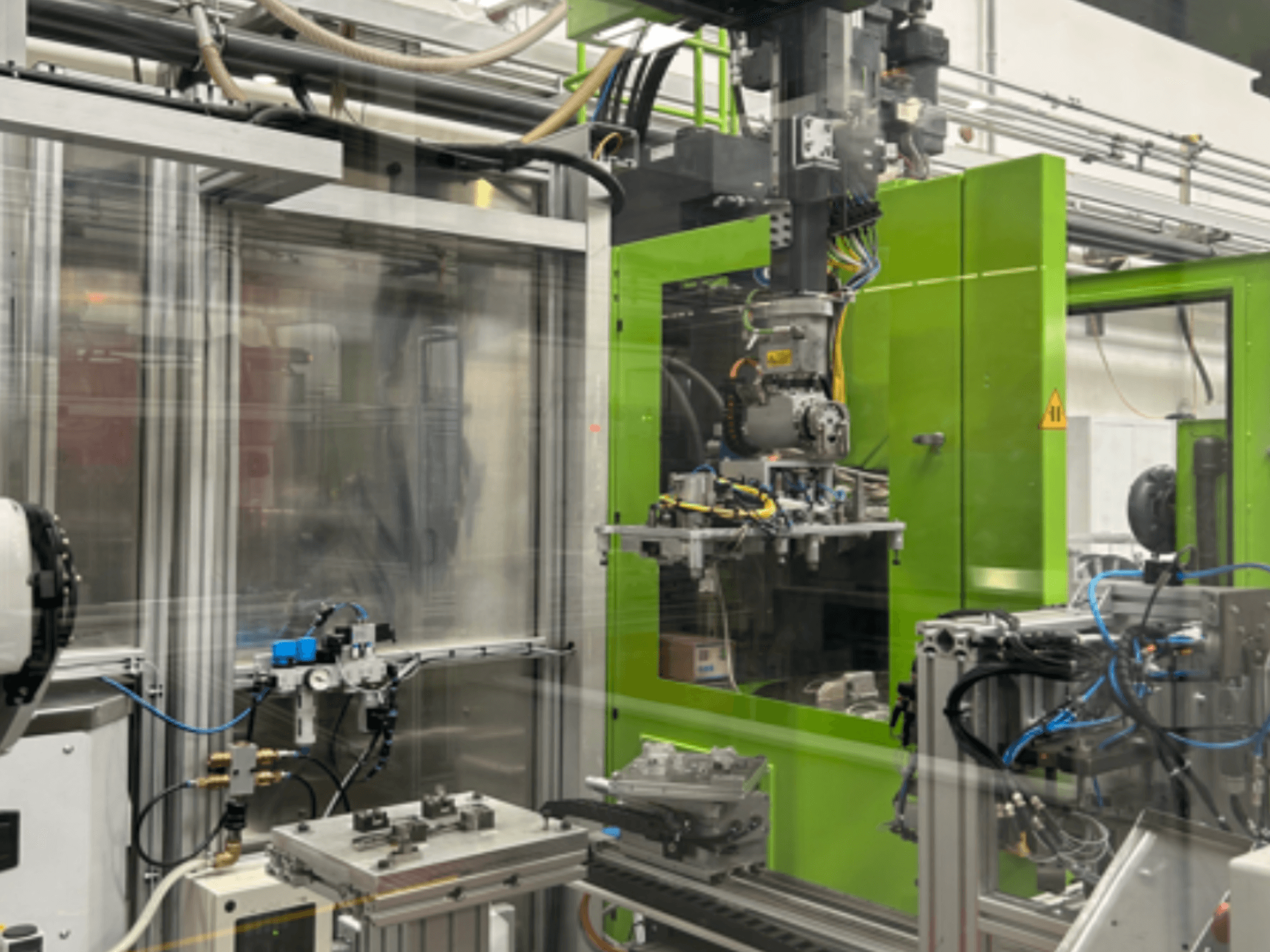 Machines robotiques industrielles dans un boîtier vert, présentant les composants mécaniques et la tuyauterie, vus de face.