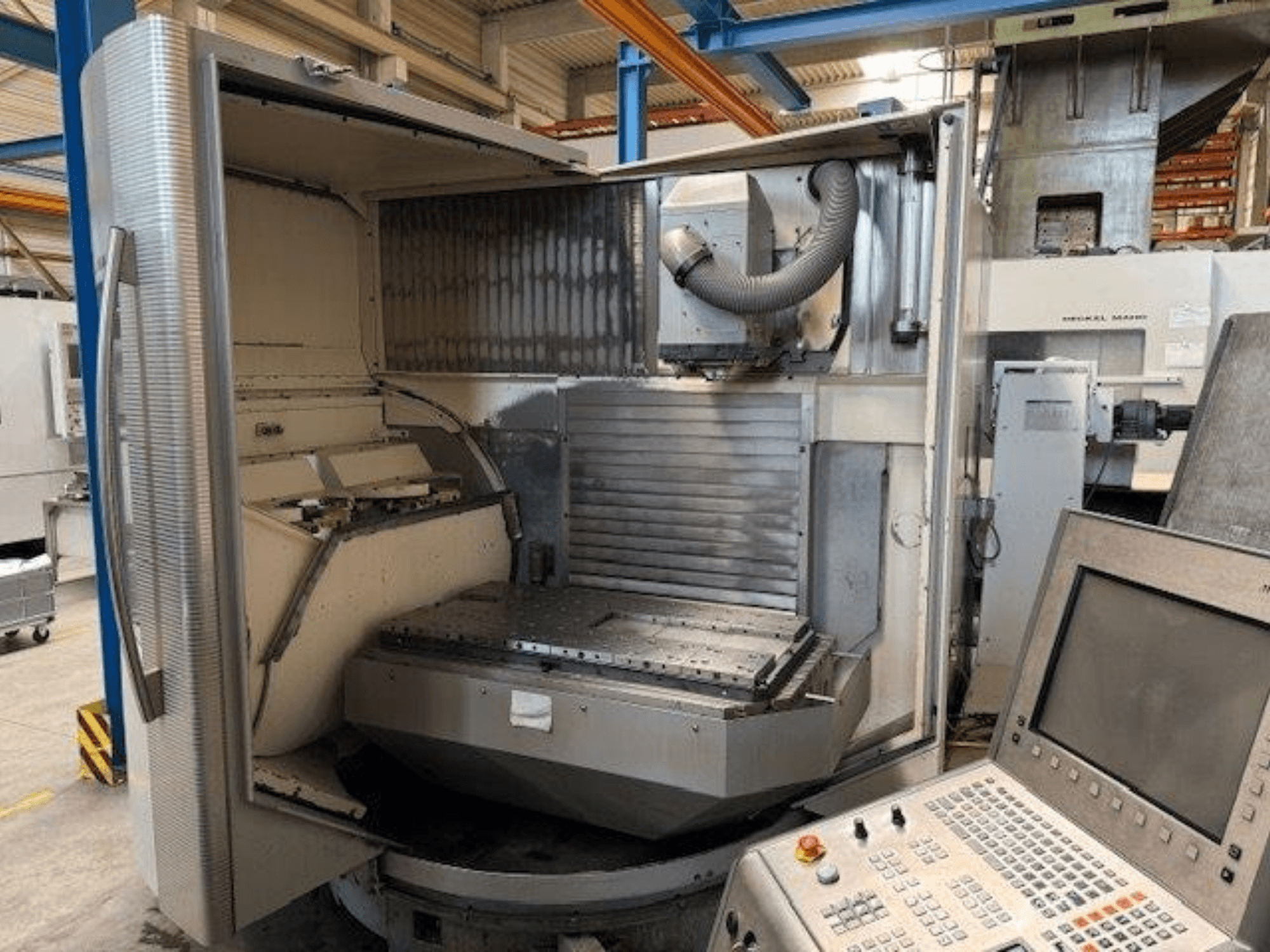 Centre d'usinage vertical DMG MORI DMU 80T, vue de face montrant le boîtier ouvert et le panneau de commande.