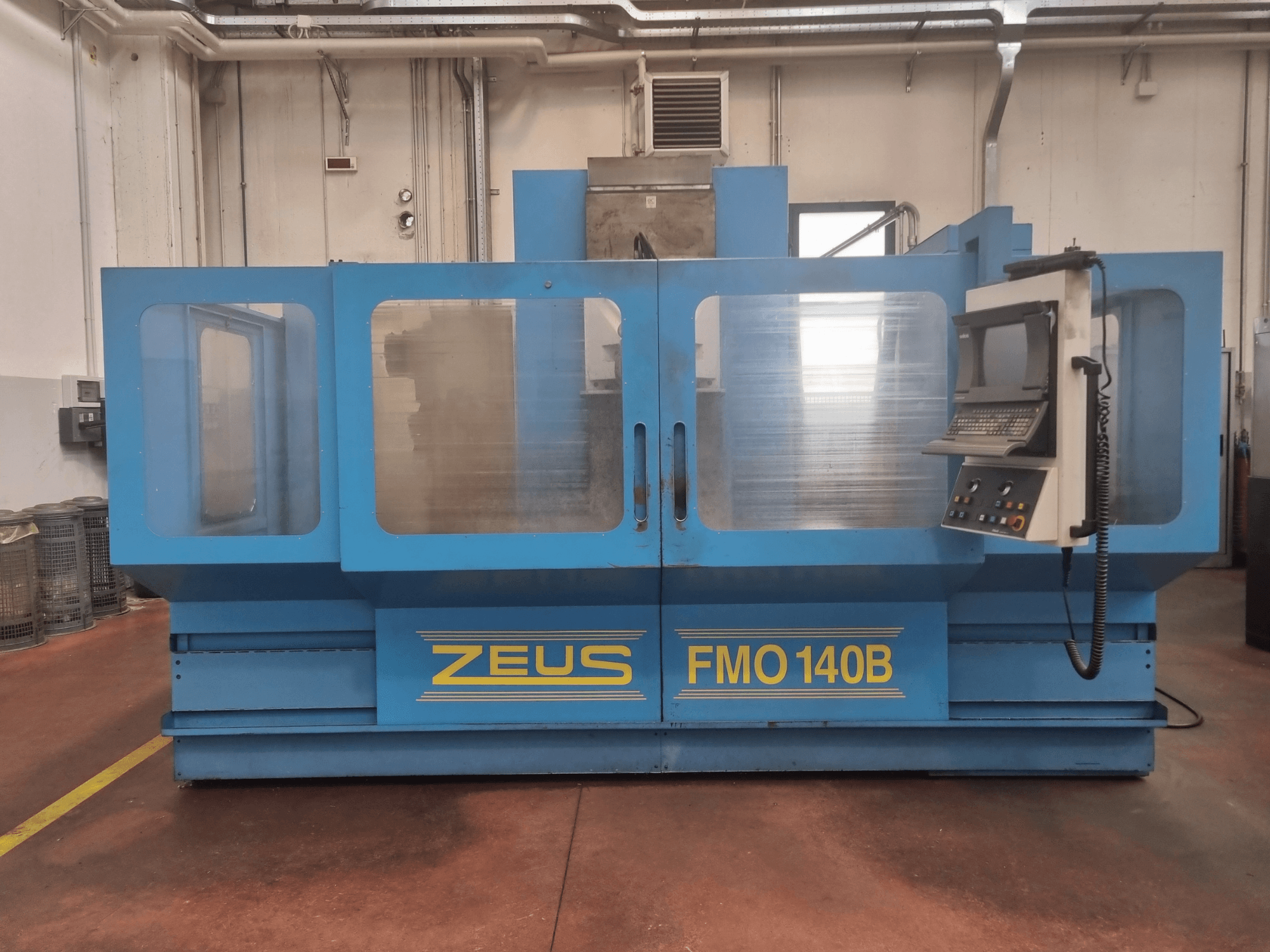 Machine Zeus FMO 140B en bleu, vue de face ; comprend un panneau de commande et de grands panneaux transparents pour une meilleure visibilité.