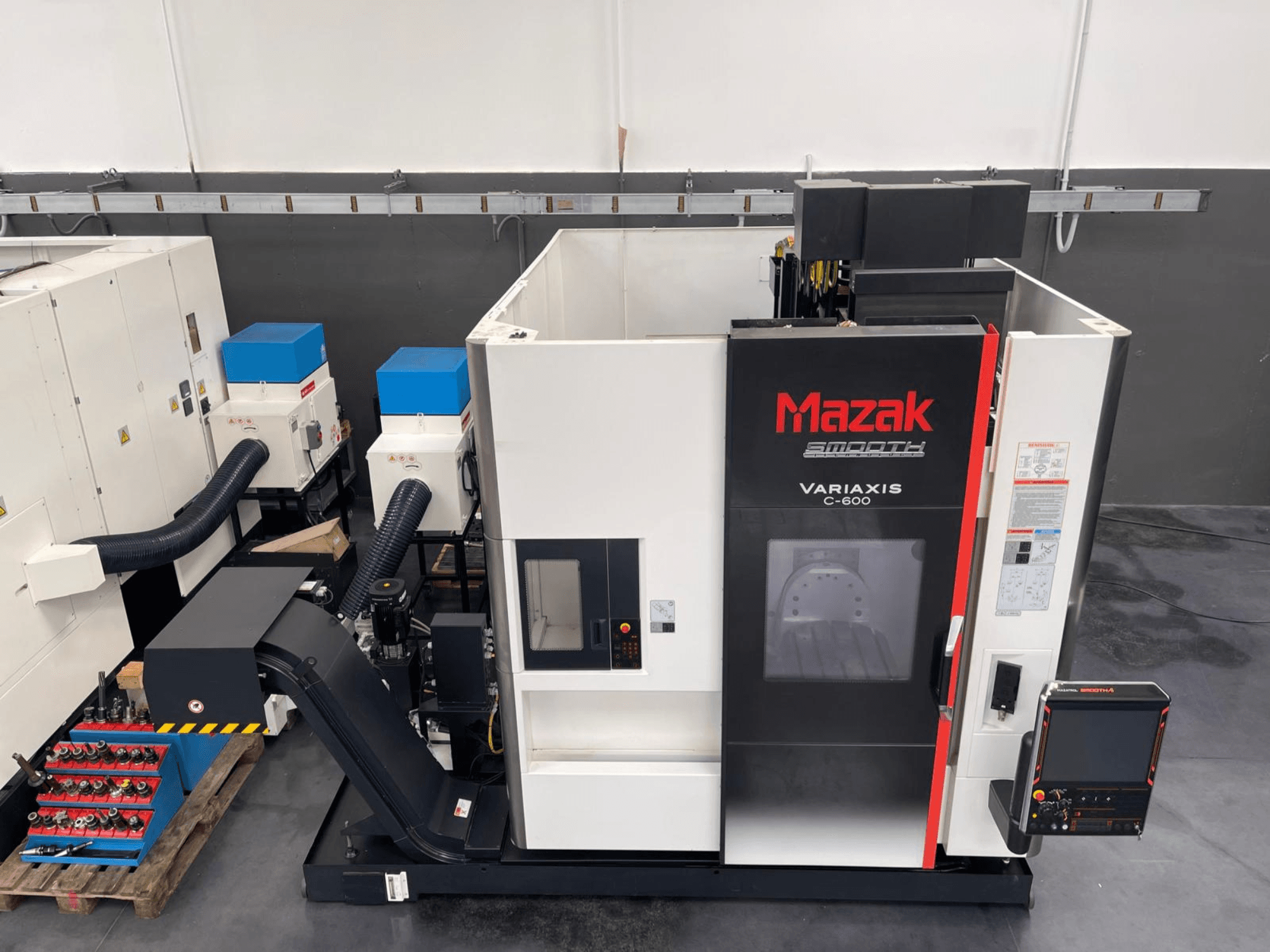 Centre d'usinage vertical Mazak VARIAXIS C 600, vue de face montrant le panneau de commande et le rangement des outils.