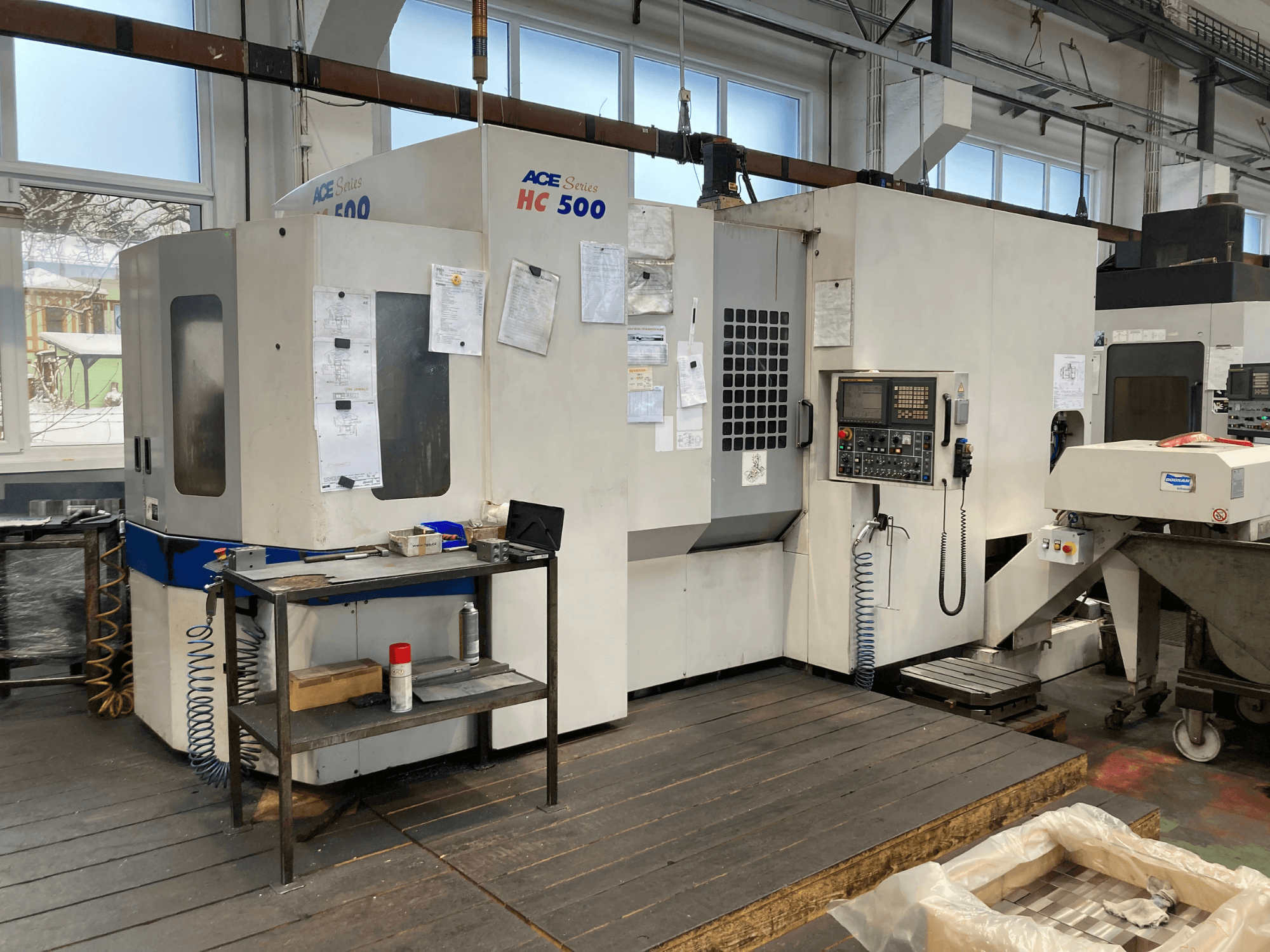 Centre d'usinage horizontal DOOSAN ACE HC-500, vue de face ; il est doté d'un panneau de commande, d'un magasin d'outils multiples et d'un environnement industriel.