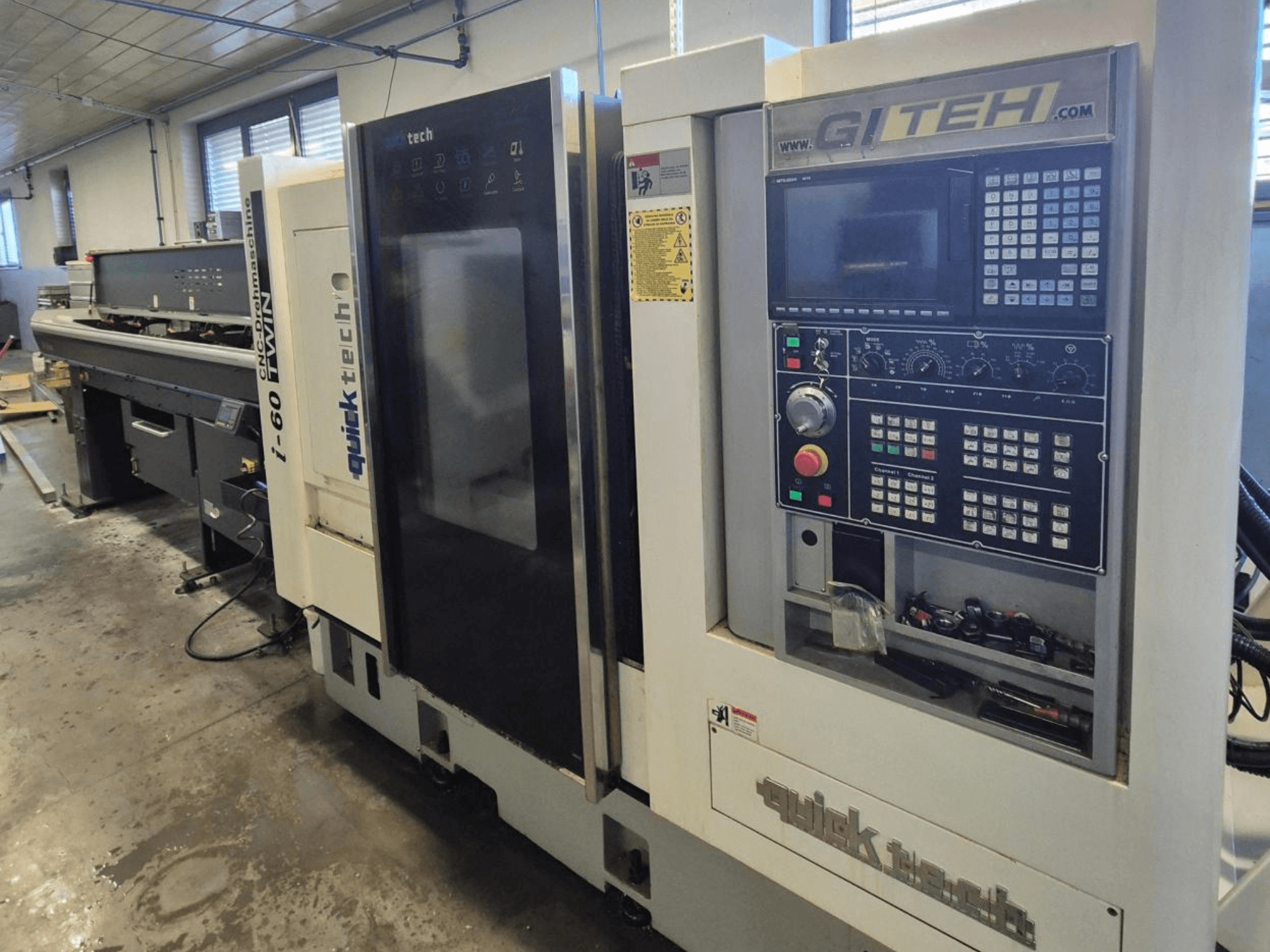 Machine CNC double Quick Tech i-60, vue de face, avec panneau de commande GITEH et boutons opérationnels, dans un atelier.
