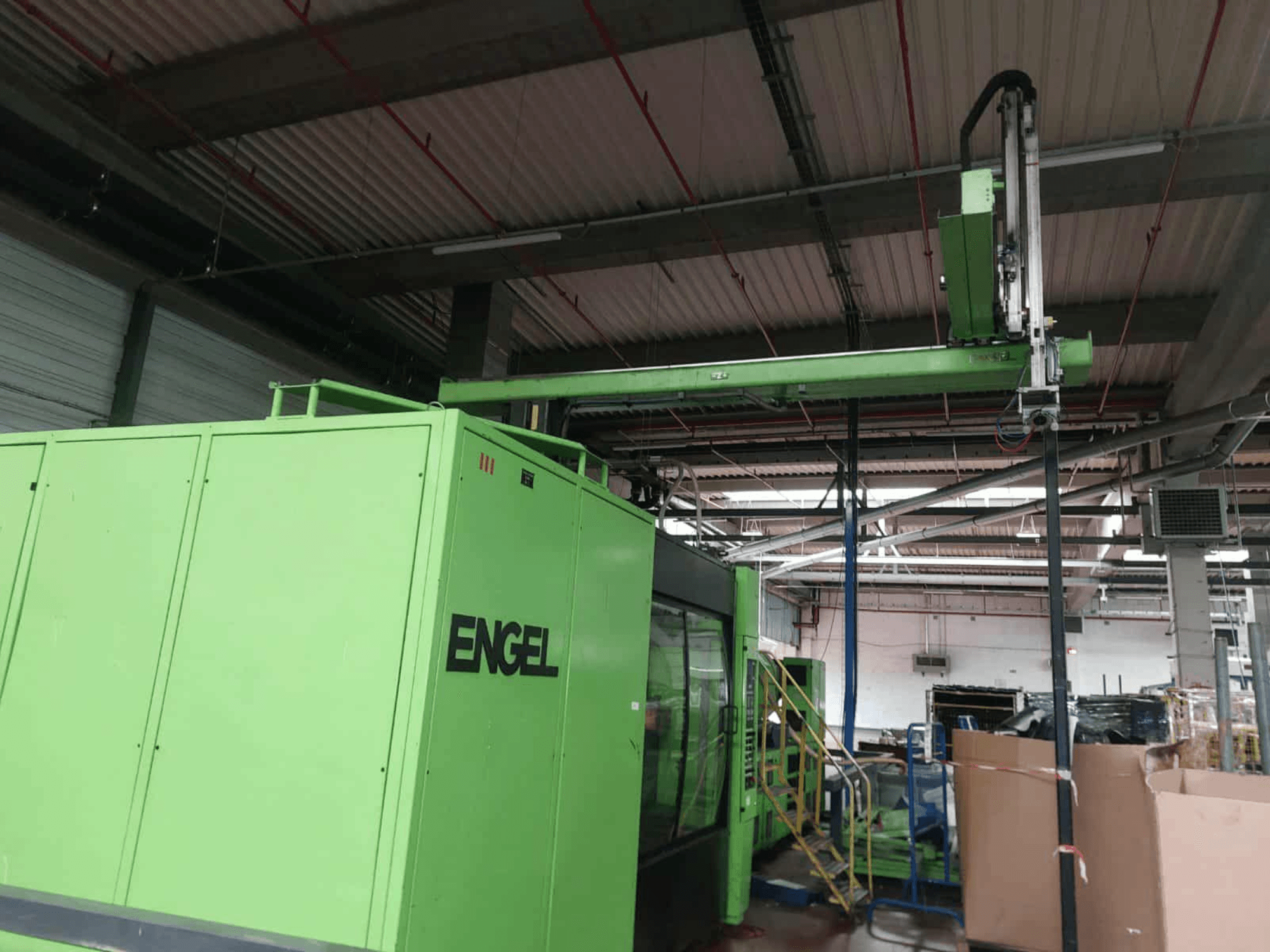 Machine de moulage par injection hydraulique Engel ES 16050/1100 DUO, vue latérale, présentant la zone de chargement et le panneau de commande.
