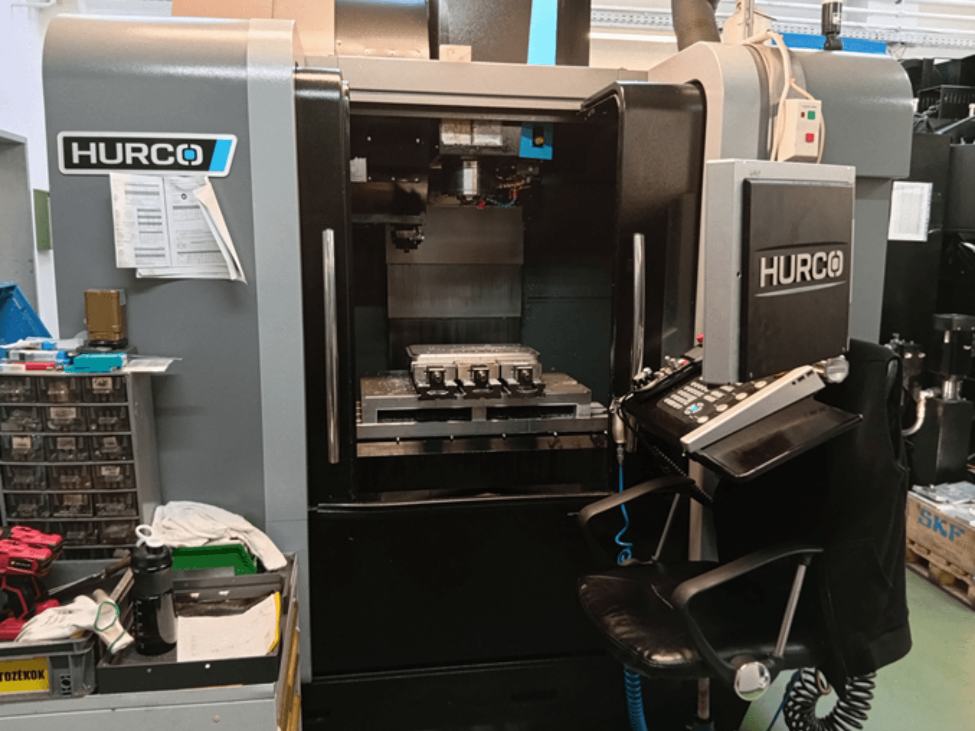 Centre d'usinage vertical Hurco VMX 30i en vue de face, avec panneau de commande, table de travail et configuration opérationnelle.
