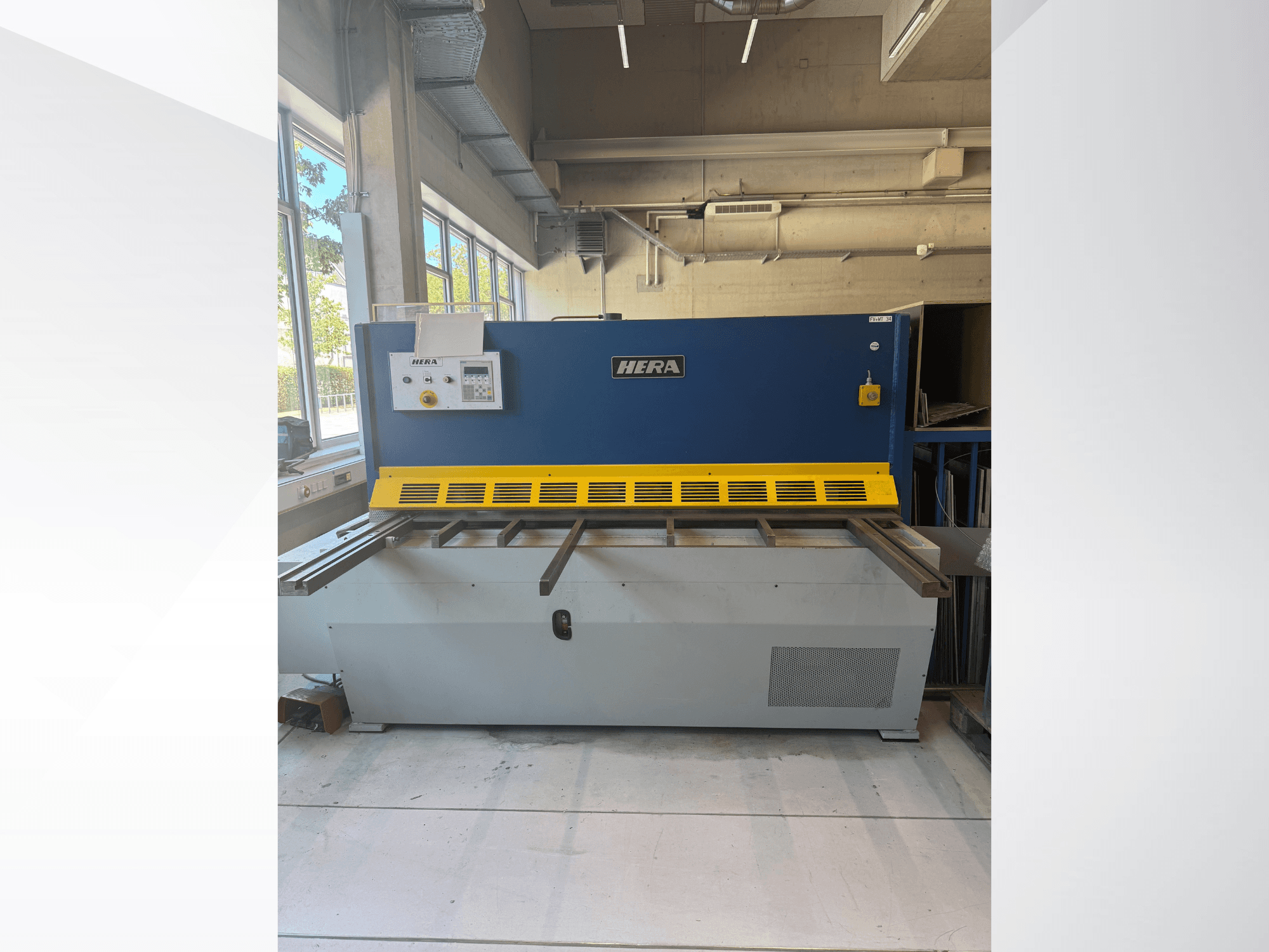 Cisaille hydraulique HERA TS 2000x6 vue de face, présentant une finition bleue et jaune avec panneau de commande et table de coupe.