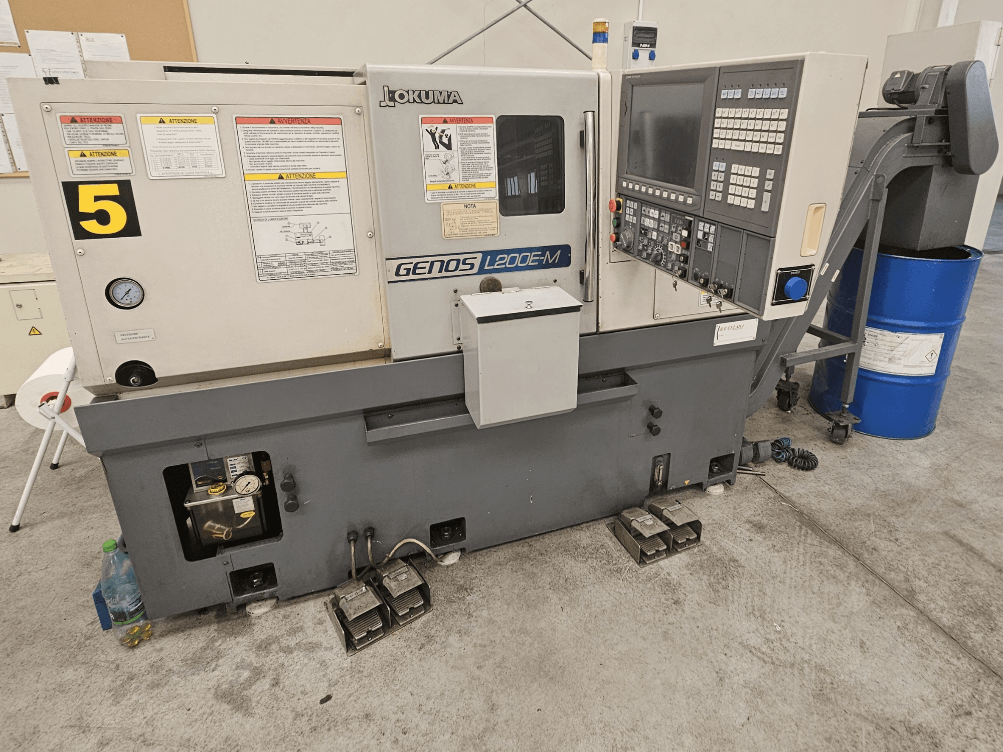 Tour horizontal Okuma GENOS L200E-M en vue de face, avec panneau de commande, étiquettes et canon d'arrosage.
