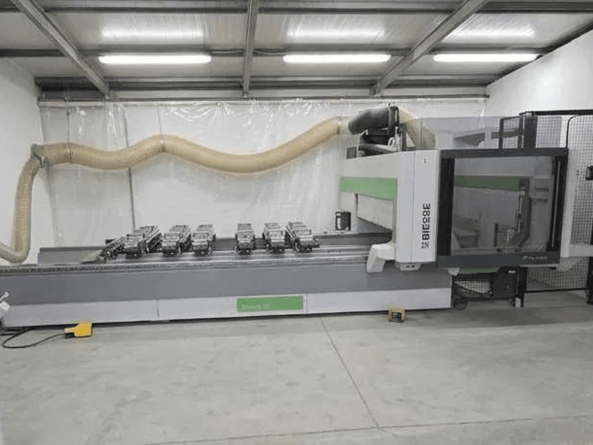 Centre d'usinage CNC BIESSE Rover K1232 vu de profil, avec les ventouses et le système d'aspiration des poussières visibles.