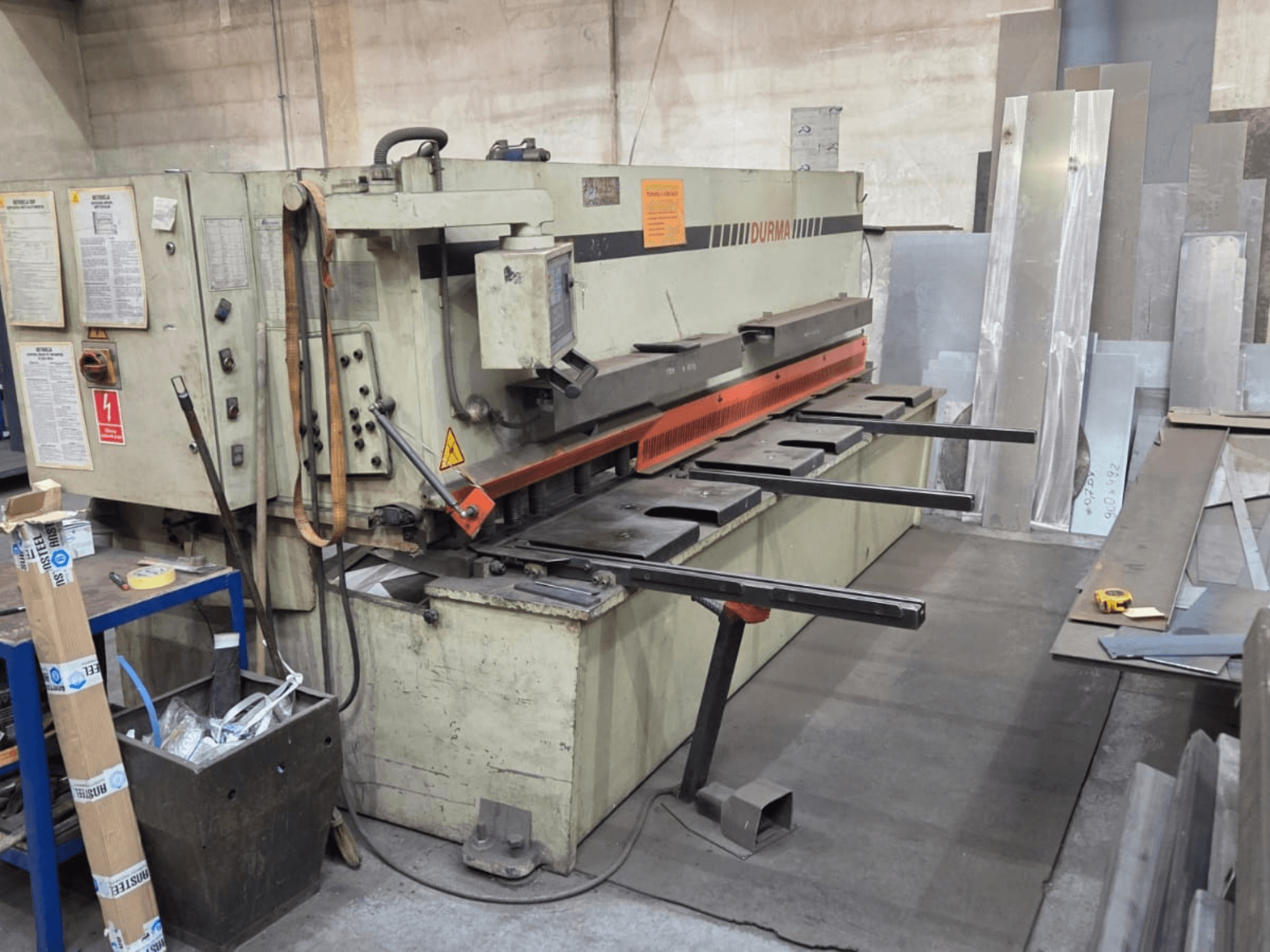 Cisaille hydraulique Durma SB 3060, vue de face, montrant les commandes, la lame de coupe et les tôles dans l'espace de travail.