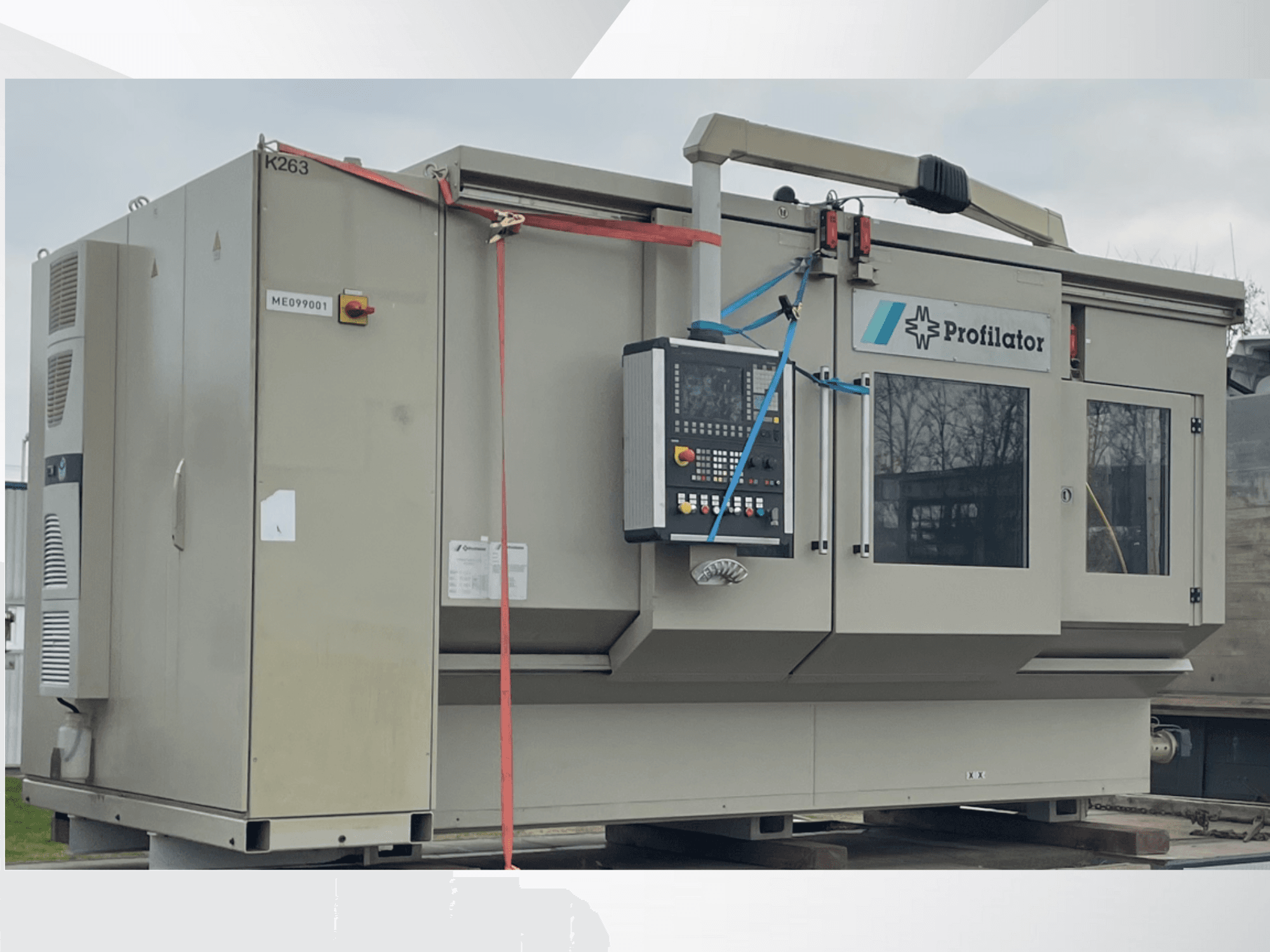 Machine à profiler vue de côté, comportant un panneau de commande, des étiquettes de sécurité et un cerclage de protection, sur une plate-forme en bois.