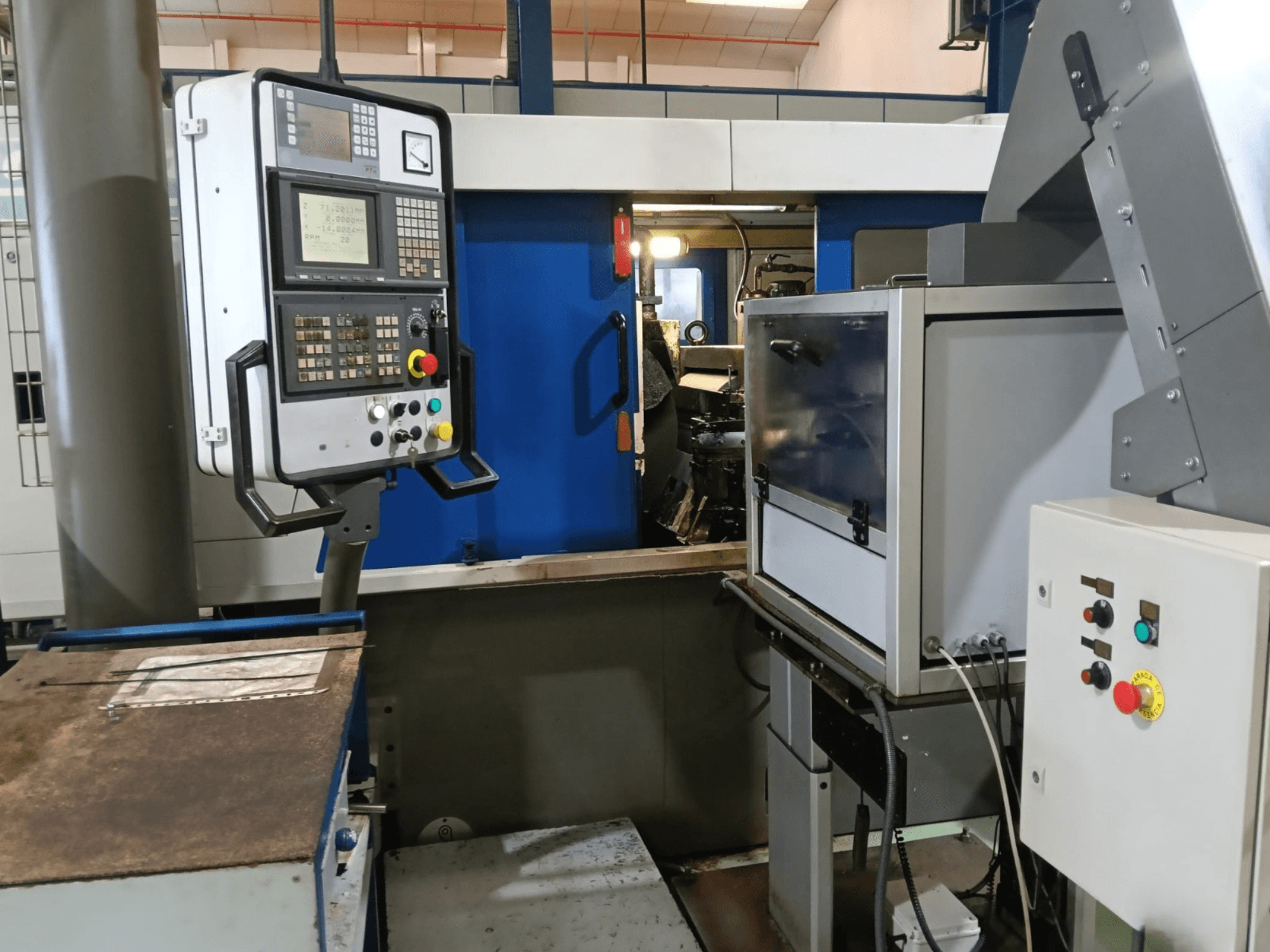 Panneau de commande et machines de la rectifieuse sans centre DANOBAT 327 MDA, vus de côté, montrant les boutons et l'écran.