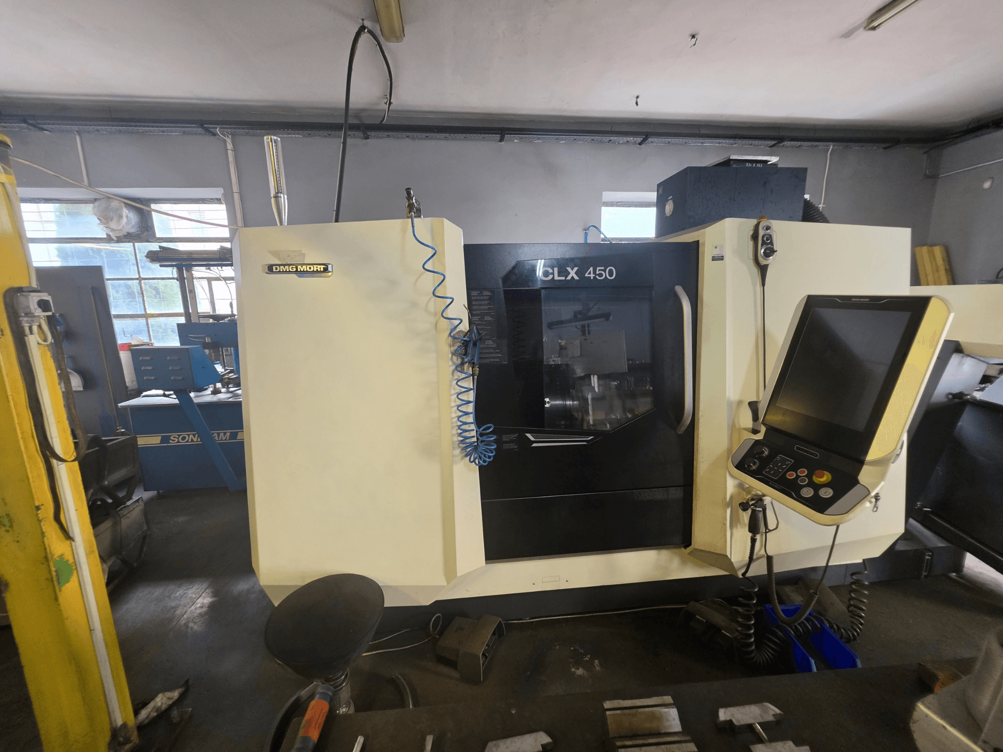 Tour horizontal DMG MORI CLX 450 V6 vu de face, avec son panneau de commande et son logo bien visible.