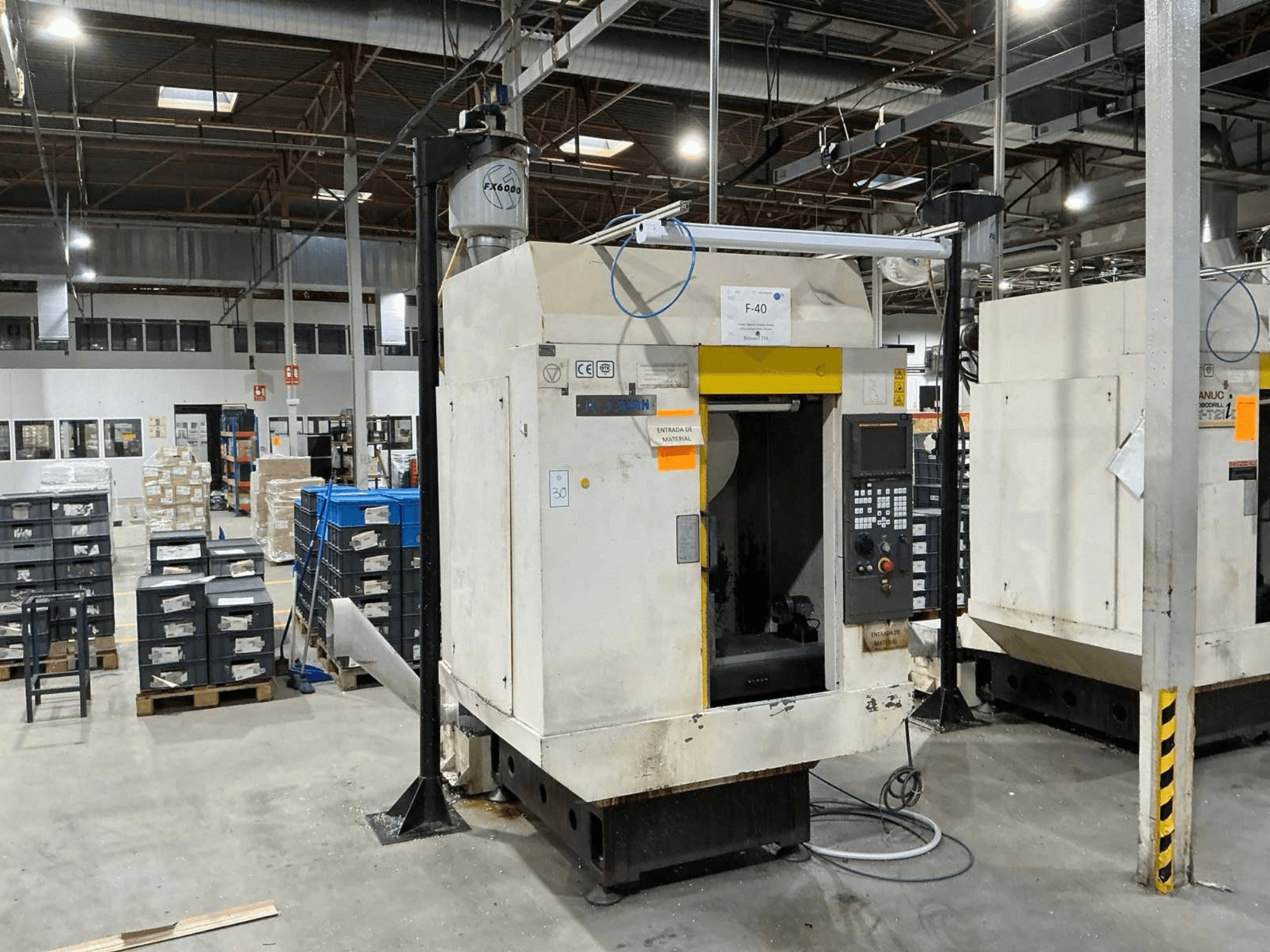 FANUC ROBODRILL α-T21iD, vue de face d'un centre d'usinage vertical dans un environnement industriel, avec les détails du panneau de commande visibles.