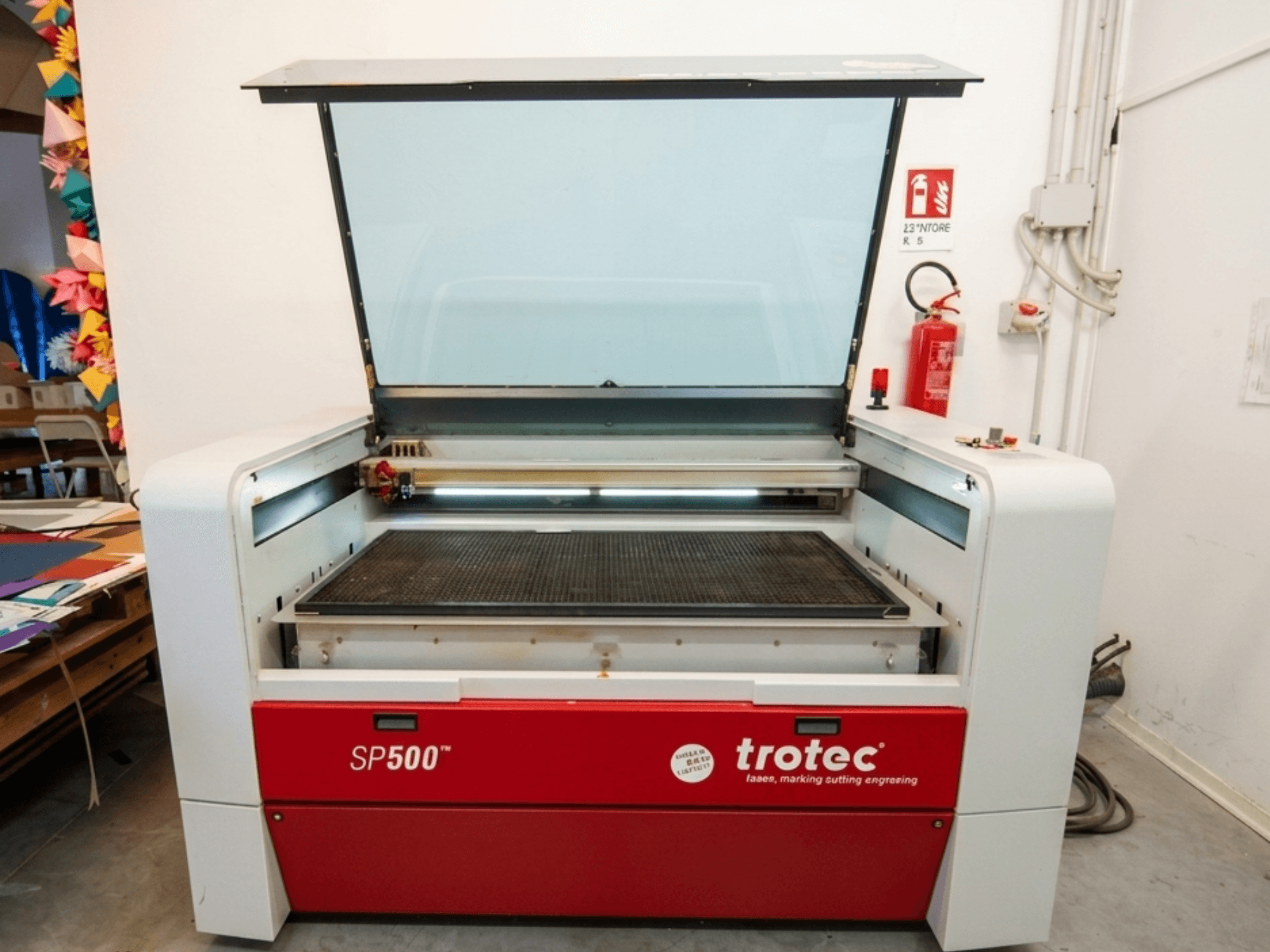 Machine de gravure laser Trotec SP500 C200 vue de face, avec un couvercle ouvert montrant la zone de travail et les commandes.