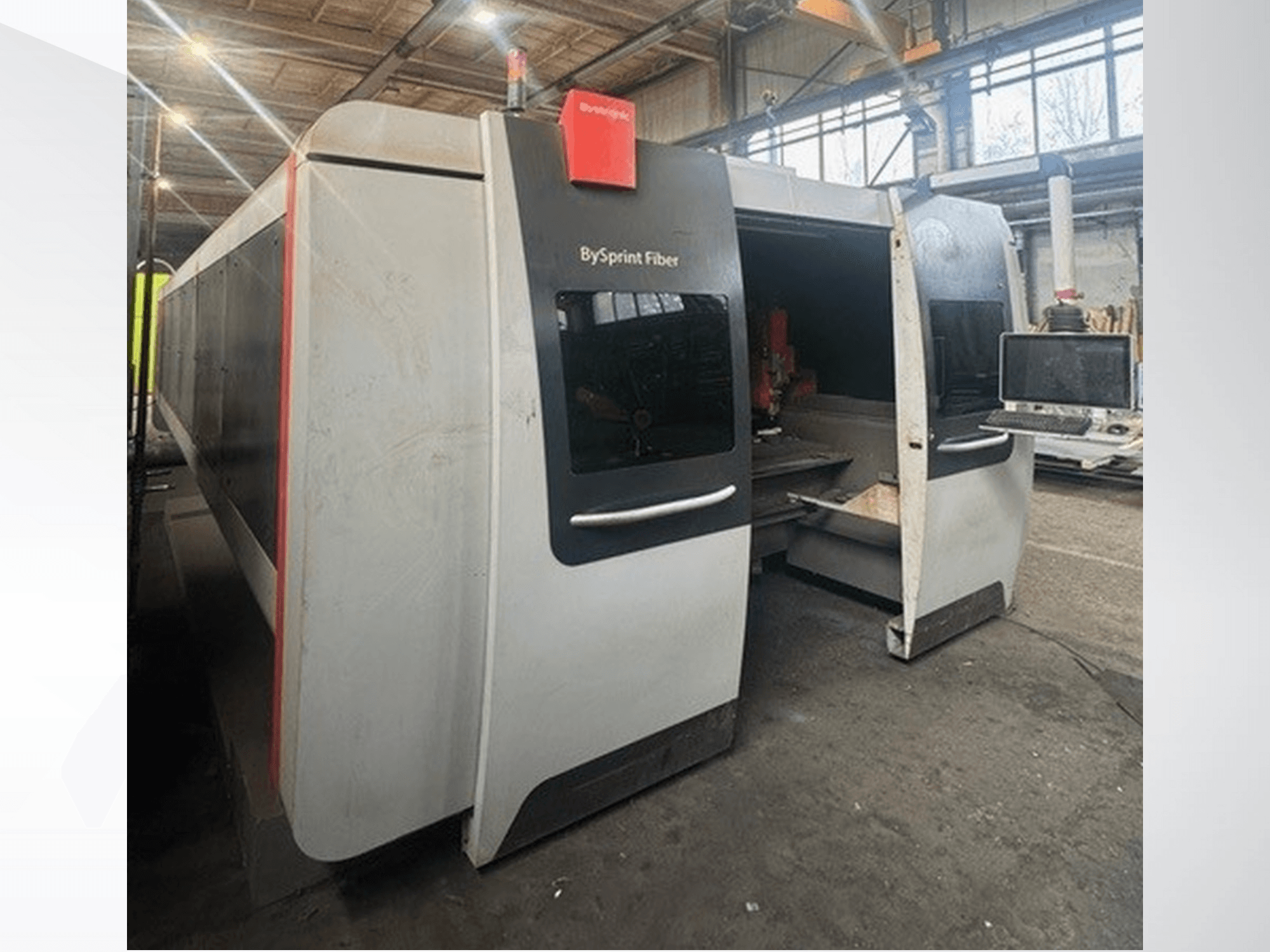 Machine BySprint Fiber de Brünswick, vue de face montrant les deux ouvertures, le panneau de commande à écran tactile et l'espace de travail industriel à l'intérieur.