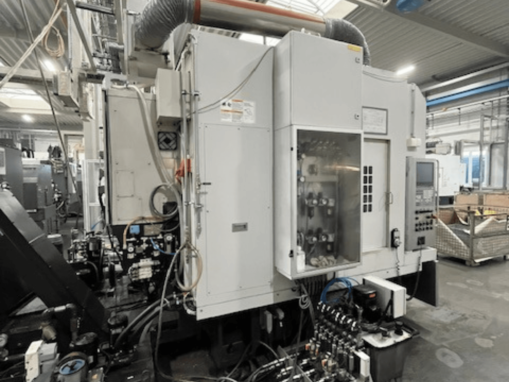 Vue latérale d'une machine industrielle présentant le panneau de commande et les composants hydrauliques, ainsi que les détails de la marque et du modèle.