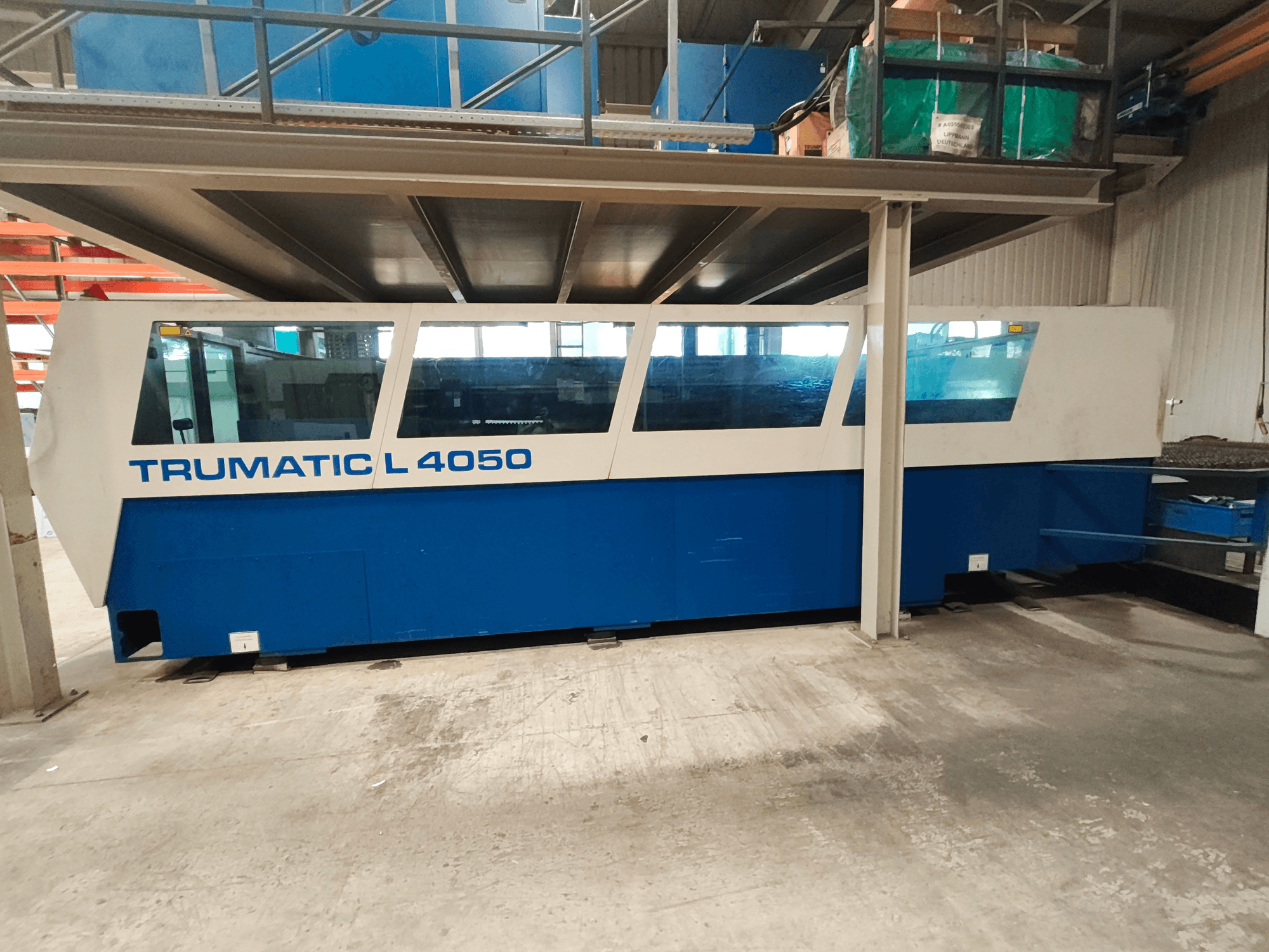 Machine de découpe laser CO₂ TRUMPF TruLaser 450 vue de profil, présentant un design bleu et blanc, avec le panneau de commande et l'espace de travail visibles.