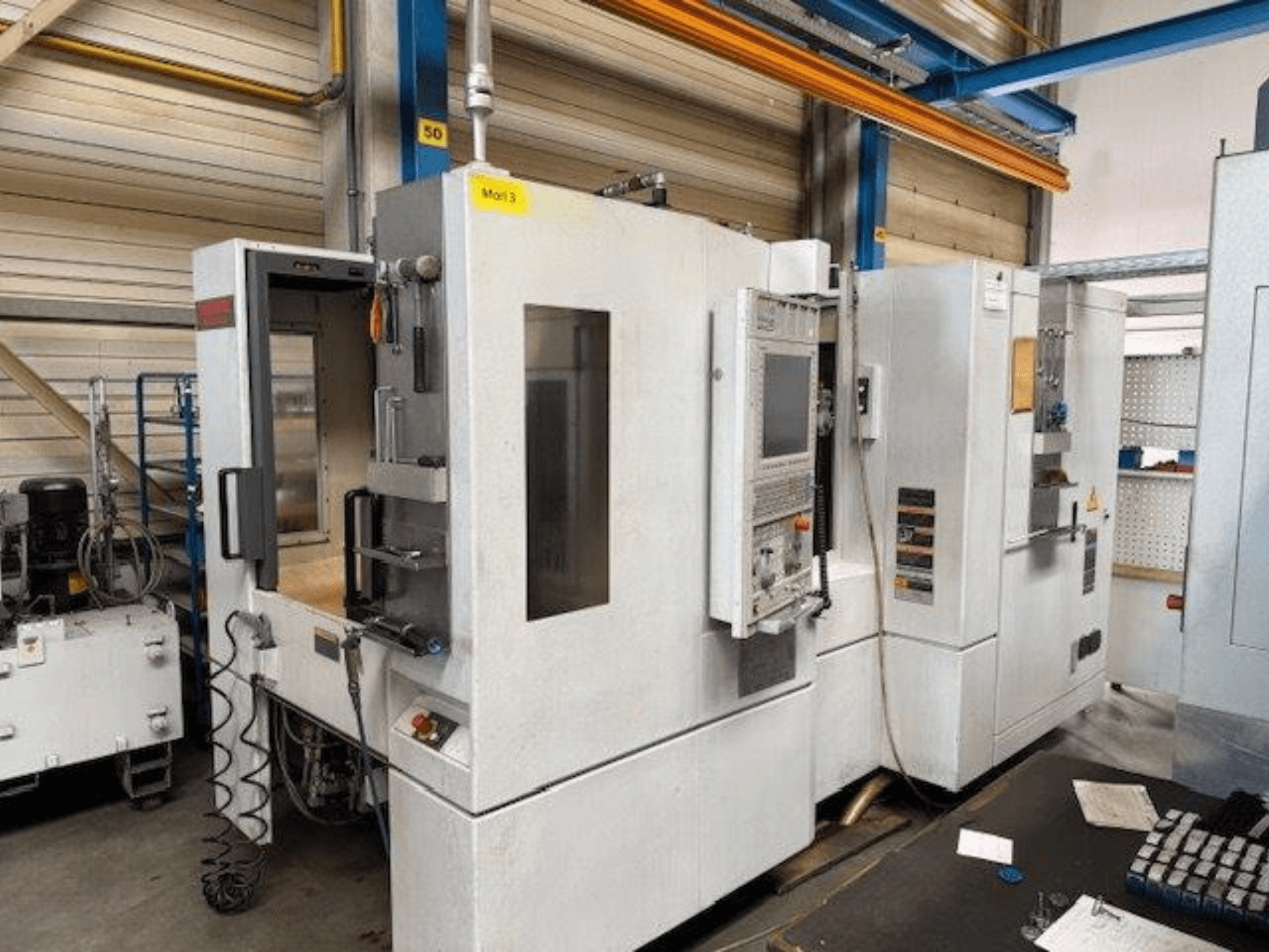 Vue de face d'un centre d'usinage horizontal MORI SEIKI NH4000 DCG avec porte ouverte et panneau de commande visible, montrant l'espace opérationnel.