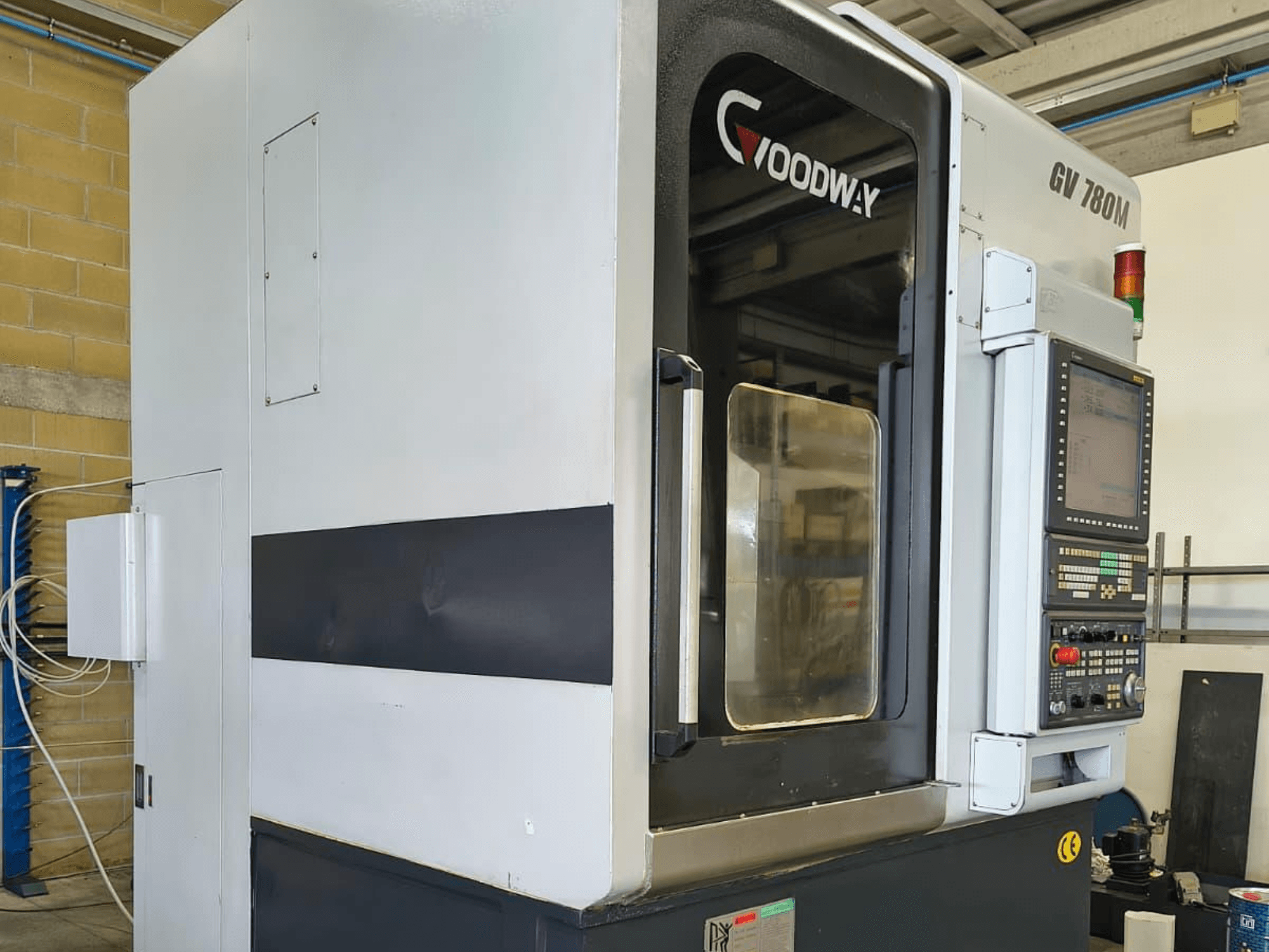 Tour vertical Goodway GV 780 M, vue latérale, présentant le panneau de commande, les dispositifs de sécurité et le design extérieur épuré.