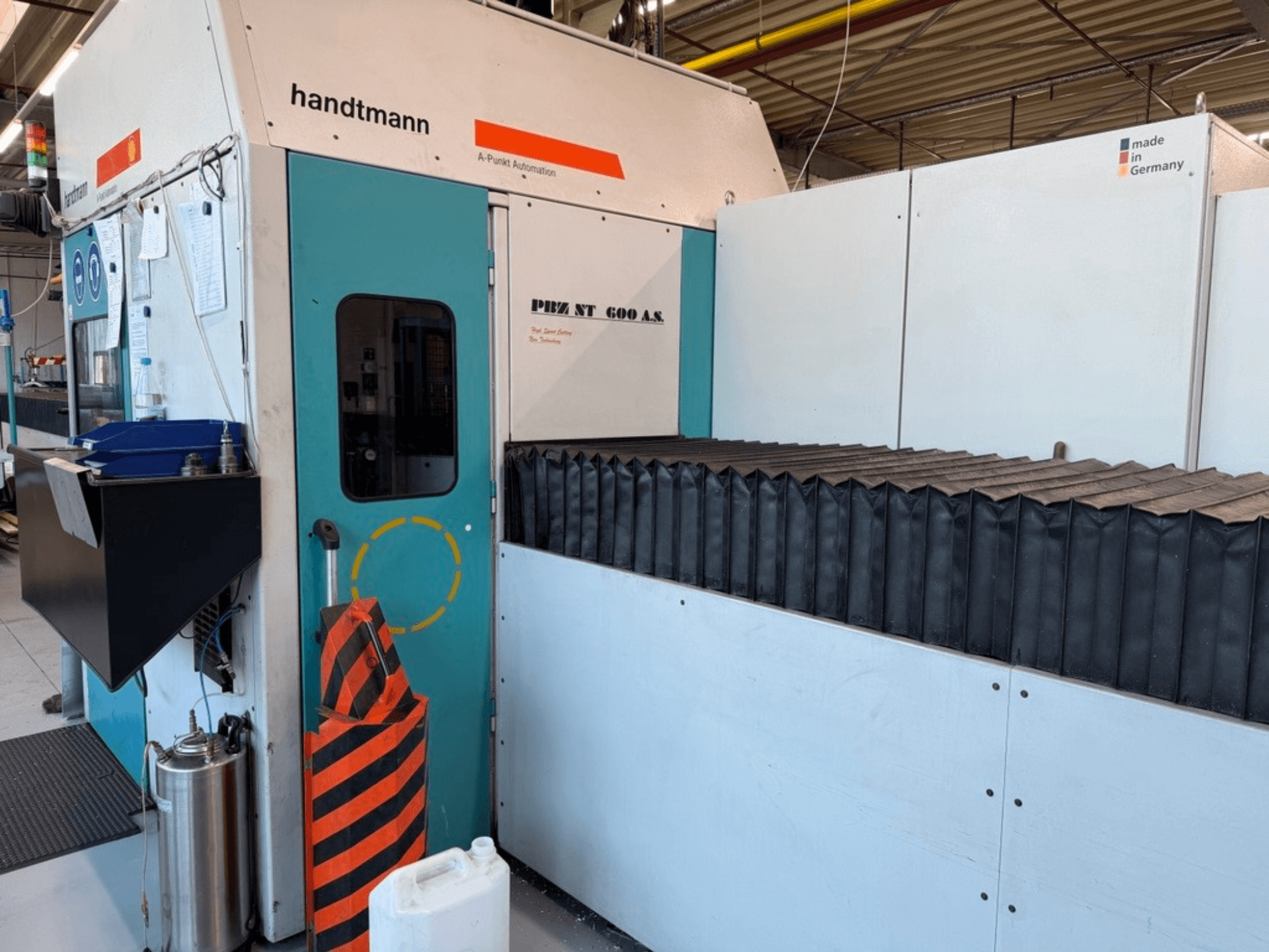 Vue de face de la fraiseuse à portique Handtmann PBZ NT 600 AS, avec une surface de travail sombre et des barrières de sécurité.