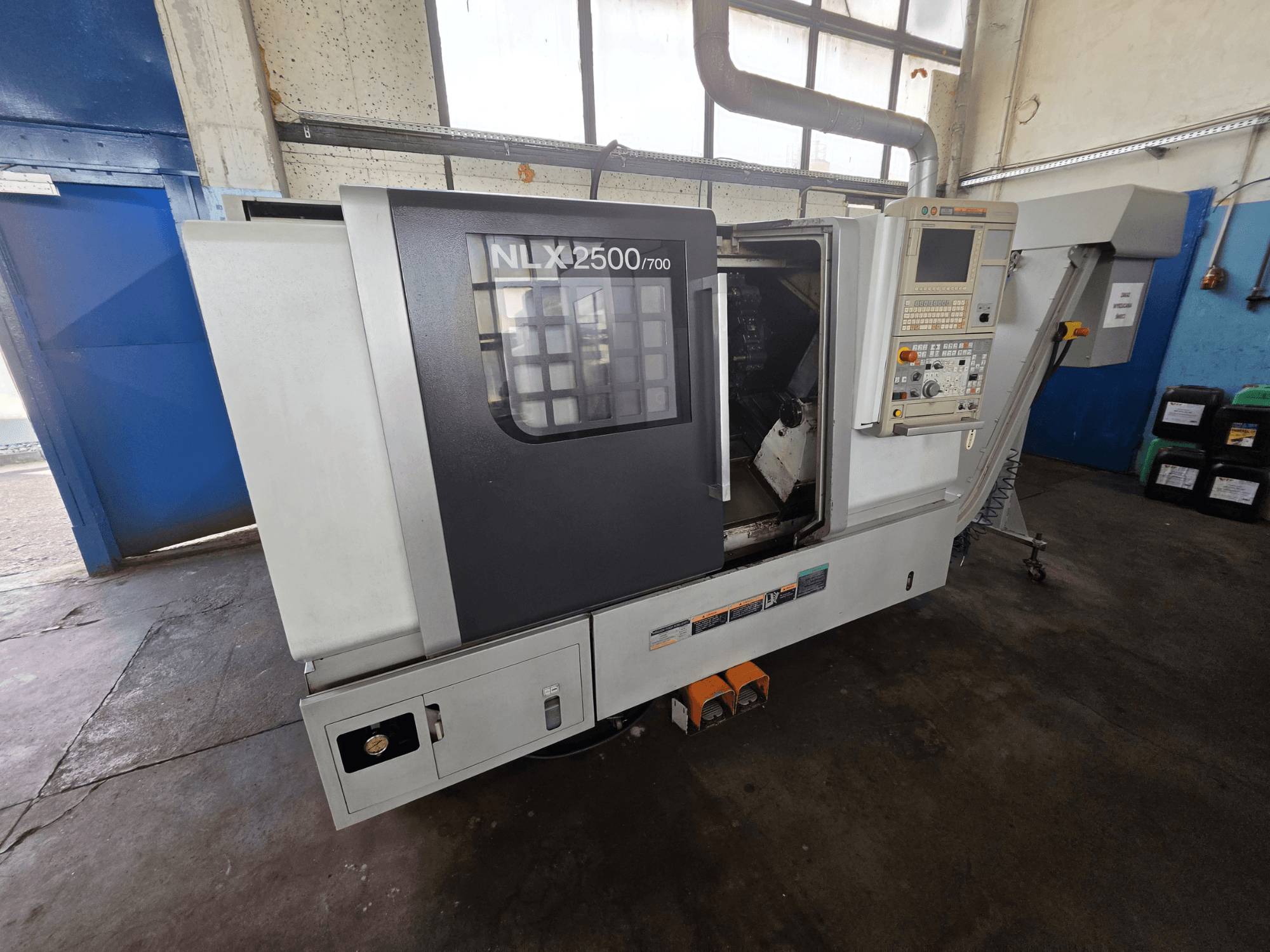 Tour horizontal DMG MORI NLX 2500/700 vu de profil, avec le panneau de commande et la zone d'usinage visible.