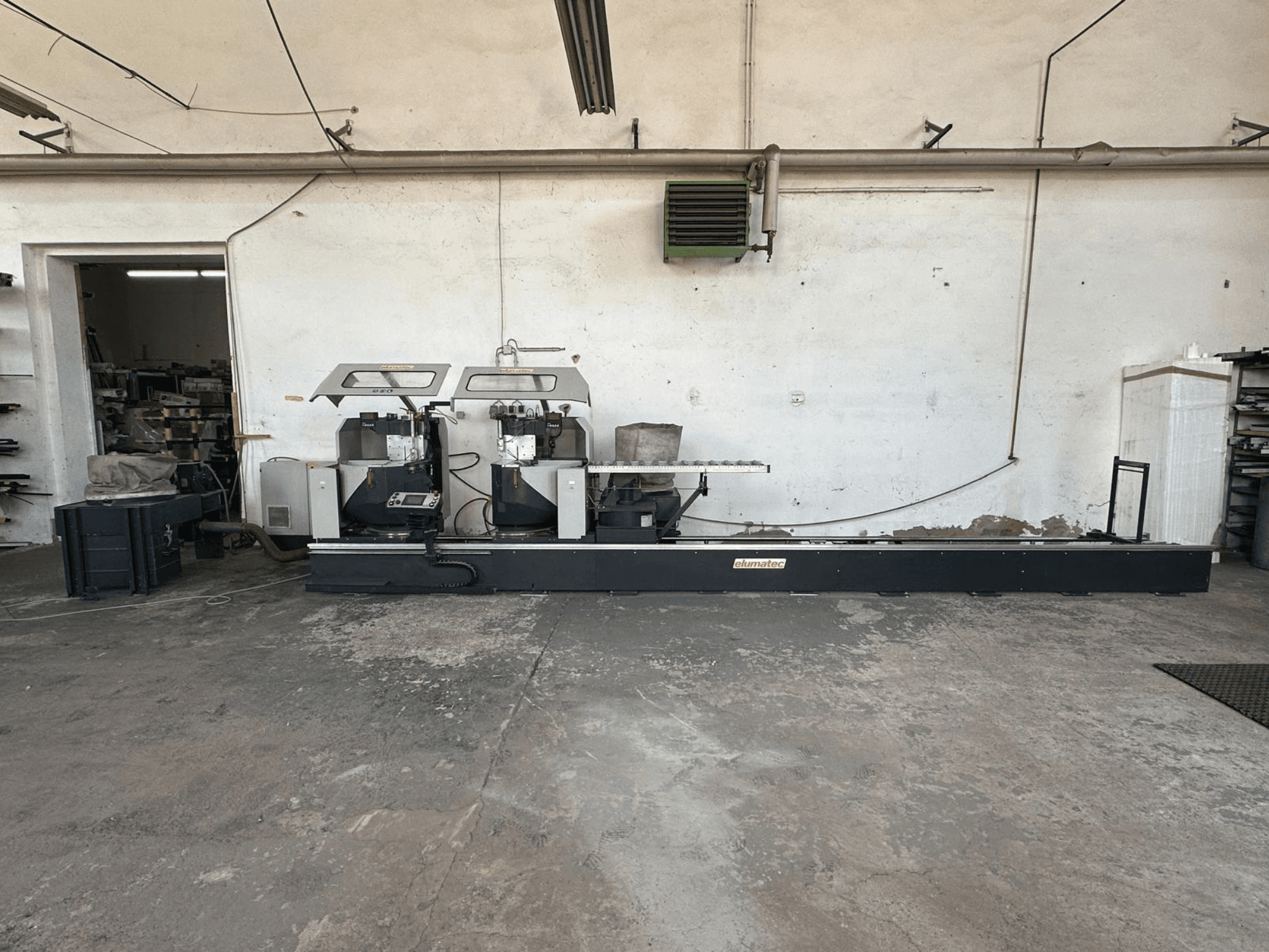 Scie circulaire à métaux Elumatec DG 244 dans un atelier, vue latérale montrant les deux scies et les commandes sur une base solide.