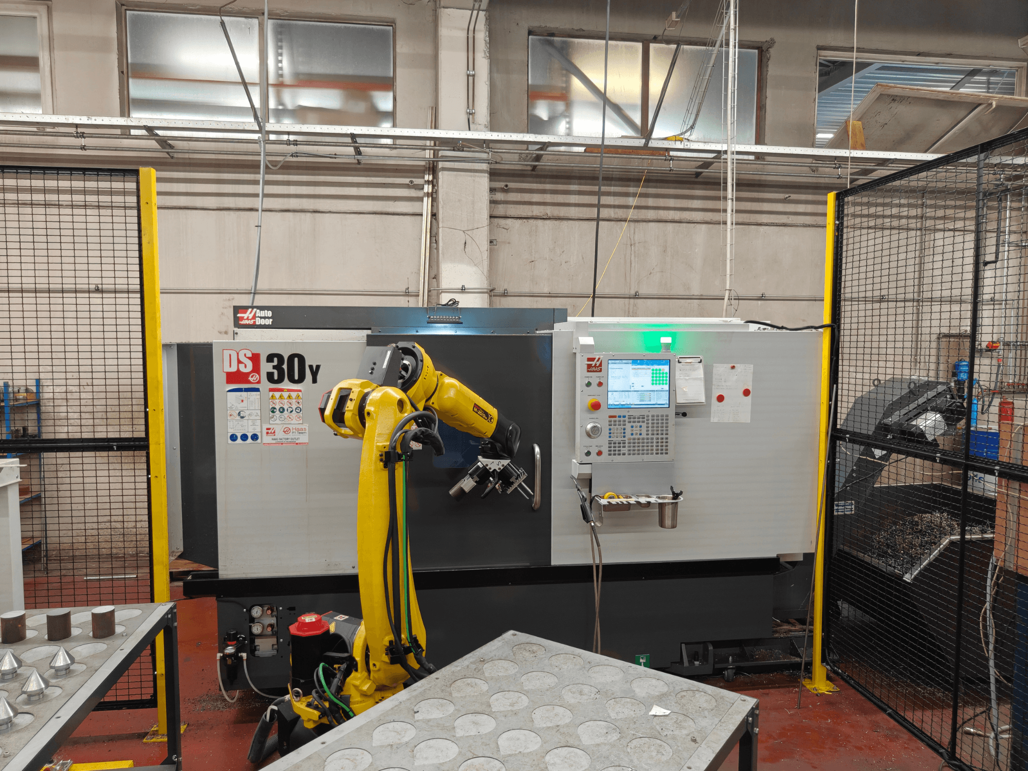 Tour horizontal HAAS DS30Y équipé d'un bras robotisé, vue de face, mettant en évidence le panneau de commande et l'espace de travail.