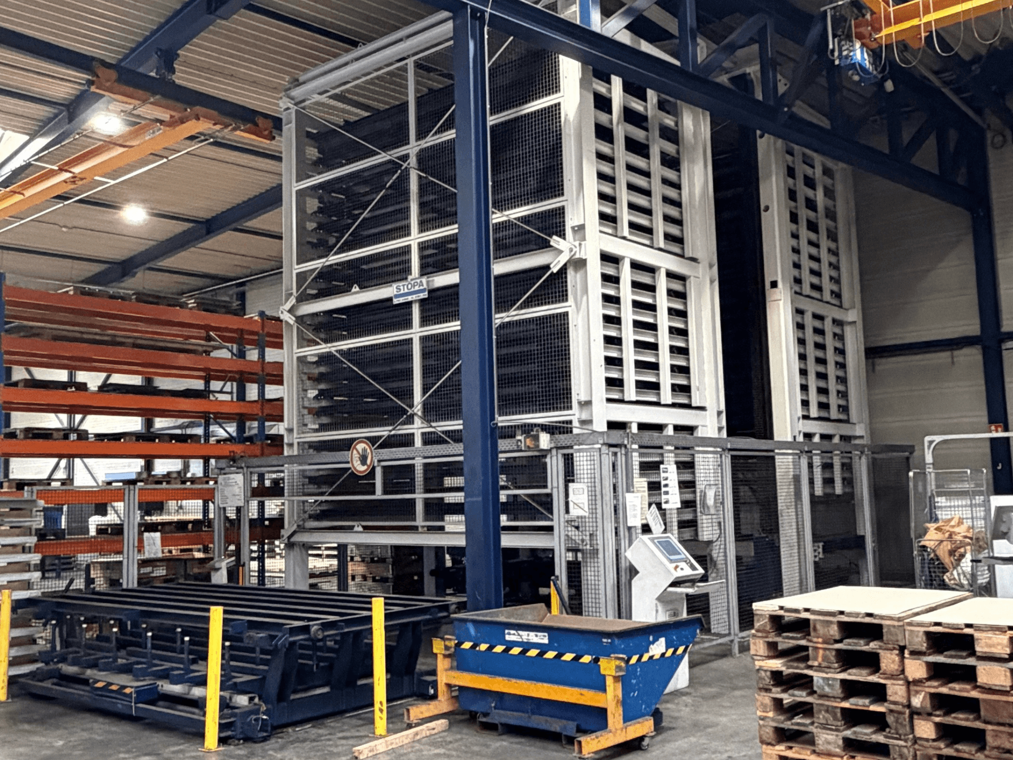 Système d'automatisation TRUMPF STOPA 4000x2000 dans un entrepôt, vue latérale montrant les rayonnages et le panneau de commande dans la zone de stockage.