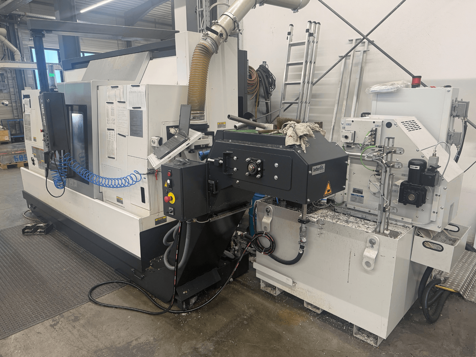 Tour horizontal Okuma LB3000II-MYC 950, vue de face, présentant le panneau de commande et le système d'arrosage.