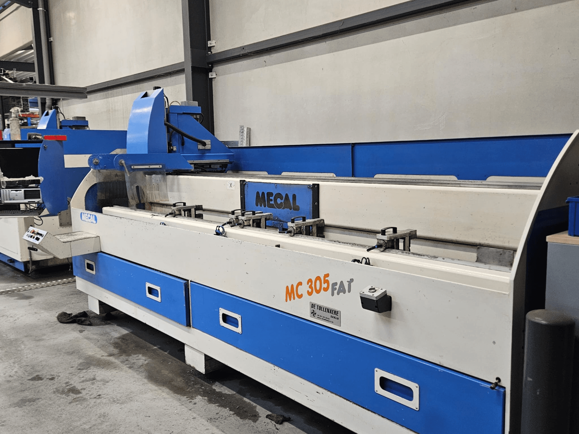 Machine MECAL MC 305 FAT en usine, vue de face montrant les commandes et le design bleu et blanc.