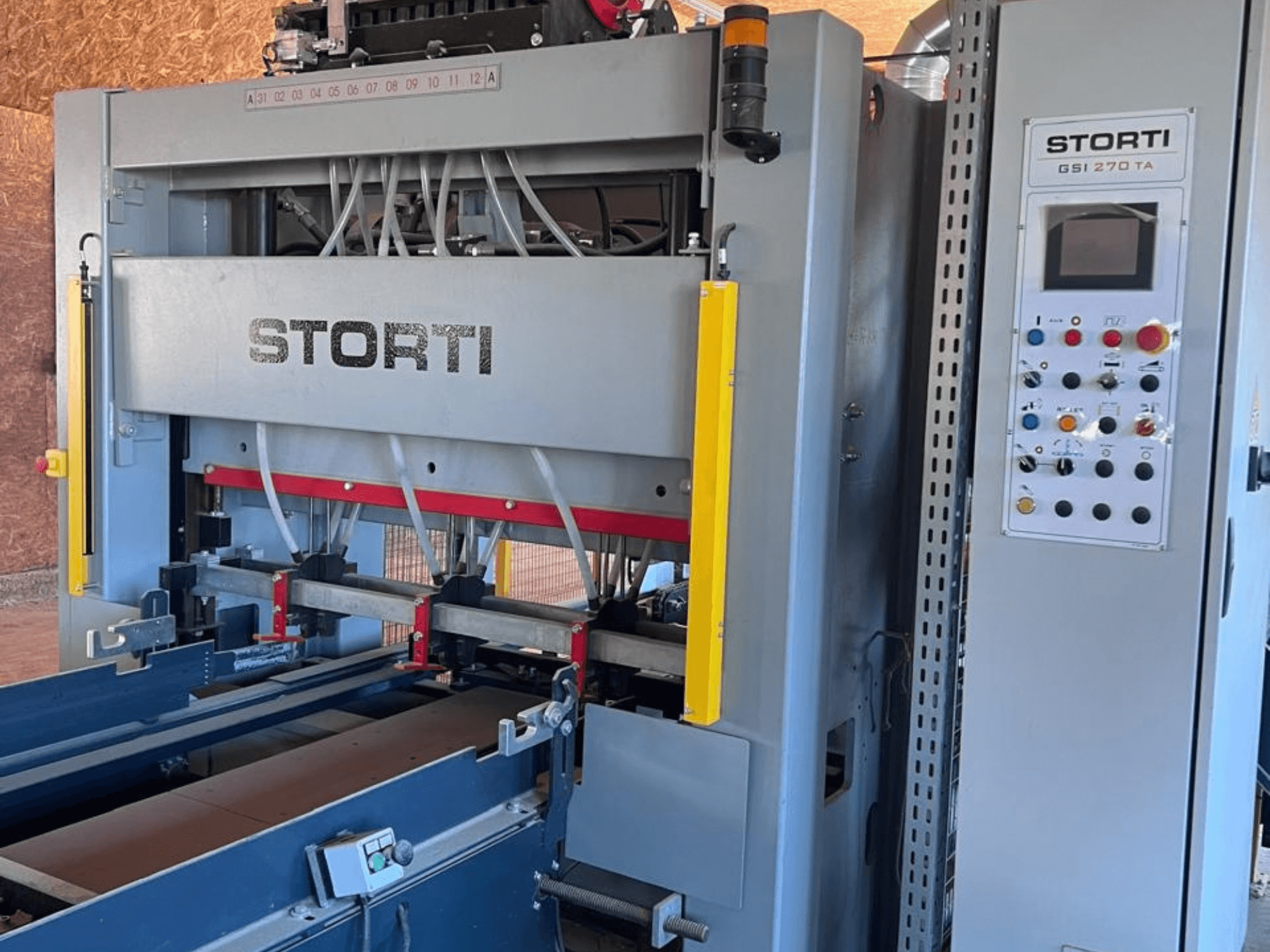 Chaîne de production de bois STORTI GSI 170-270 TA9, vue de face montrant le tableau de commande et les mécanismes de la presse hydraulique.