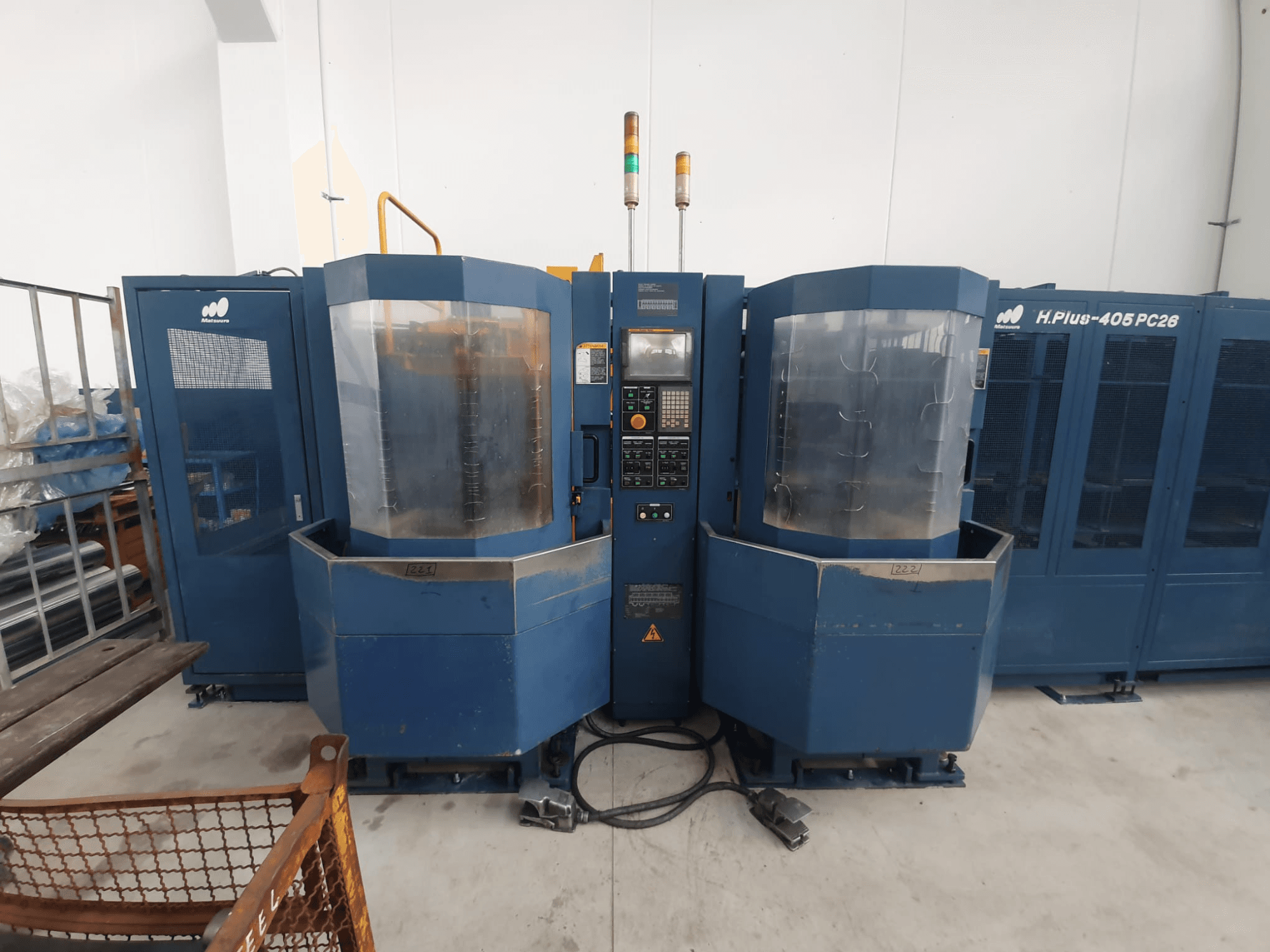 Machine-outil double H.Plus 406 PC26, vue de face, comprenant le panneau de commande, le boîtier transparent et la base de la machine connectée.