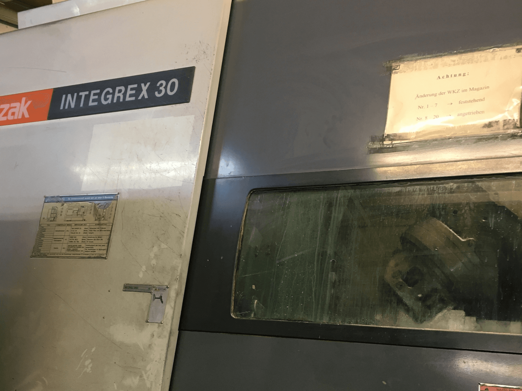 Vue de face du centre de tournage-fraisage Mazak Integrex 30 Y Universal 1000, mettant en évidence les commandes de fonctionnement et l'outillage visible à travers la vitre.