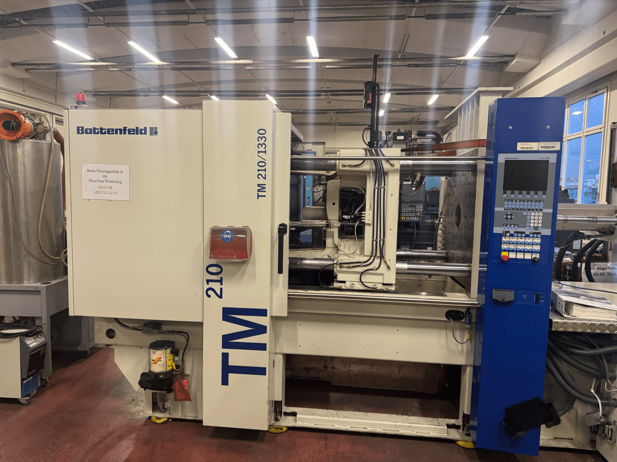 Machine de moulage par injection hydraulique Battenfeld TM 210/1330, vue de face, montrant le panneau de commande et les composants de la machine.