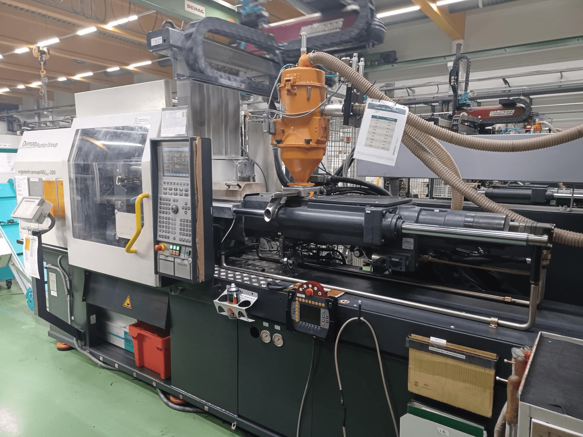 Machine de moulage par injection Demag Ergotech 200, vue de face, avec le panneau de commande, la buse et les composants opérationnels visibles.