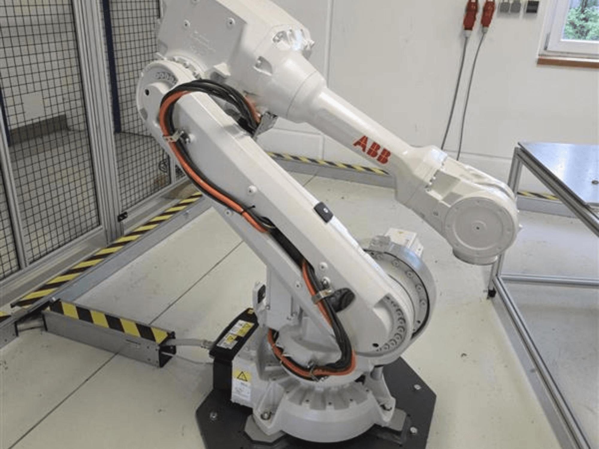 Bras robotisé ABB IRB 4600-45/2.05 vu de profil, mettant en évidence sa conception articulée et les câbles reliés à la base.