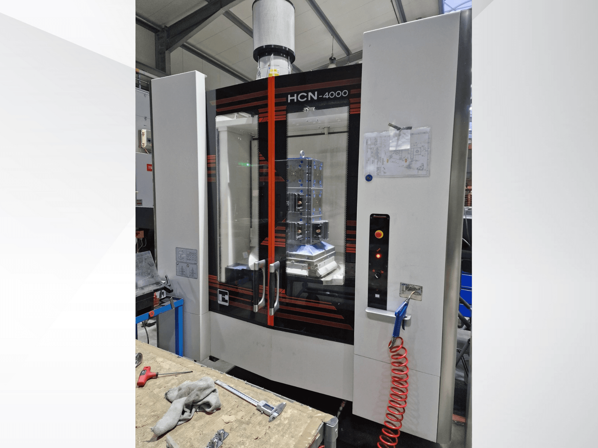 Machine CNC HCN-4000 vue de face, comprenant un panneau en verre, un panneau de commande avec des boutons, et un plan joint.